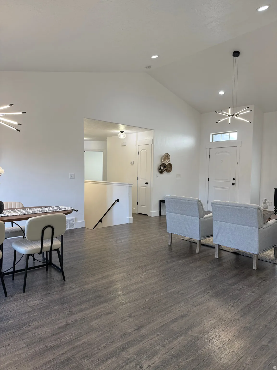 Dining area featuring a chandelier, lofted ceiling, dark wood-type flooring, and recessed lighting