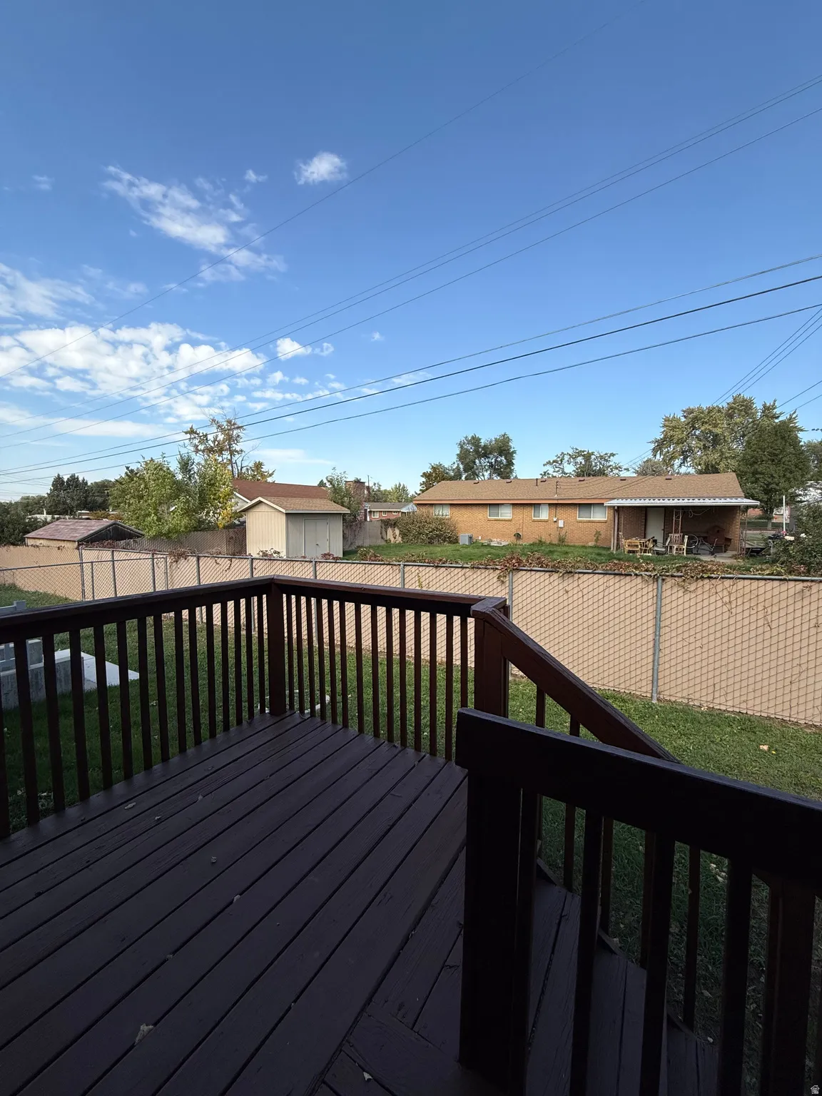 Wooden deck featuring a fenced backyard and an outdoor structure