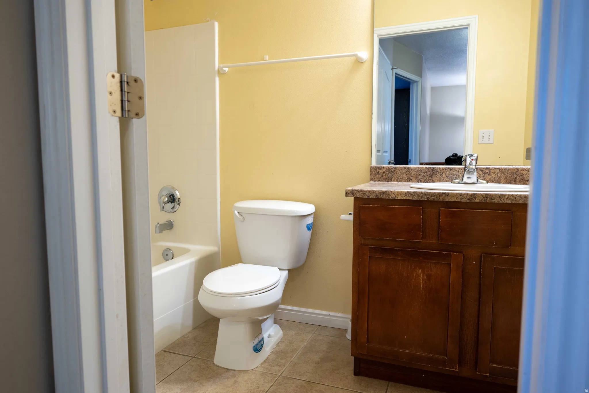 Full bath with light tile patterned flooring, vanity, and bathtub / shower combination
