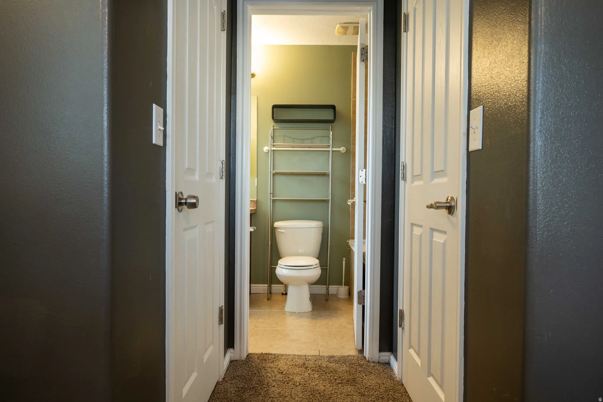 Bathroom featuring light tile patterned floors and light carpet