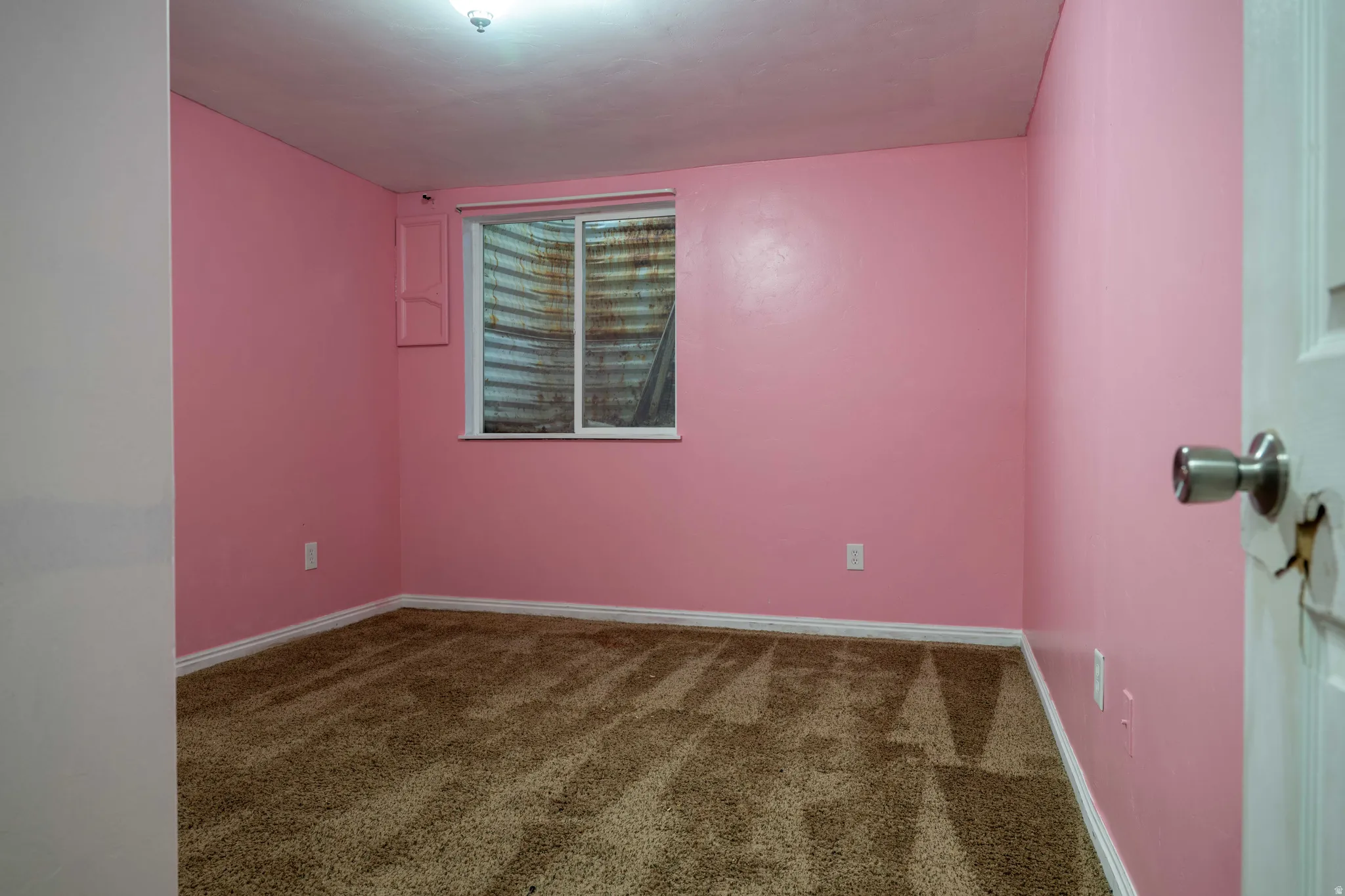 Carpeted empty room with baseboards