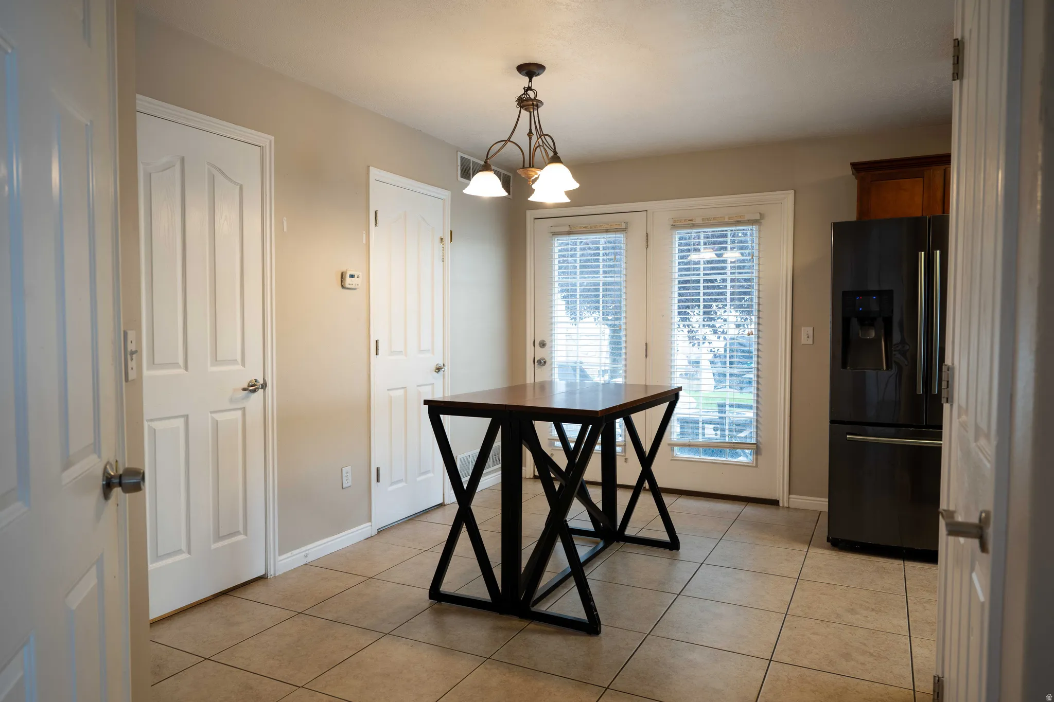 Unfurnished dining area featuring a chandelier and light tile patterned floors