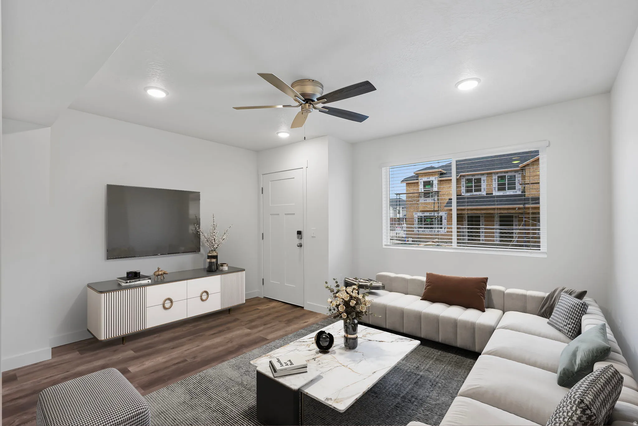 Living area featuring dark wood-type flooring, a ceiling fan, and recessed lighting