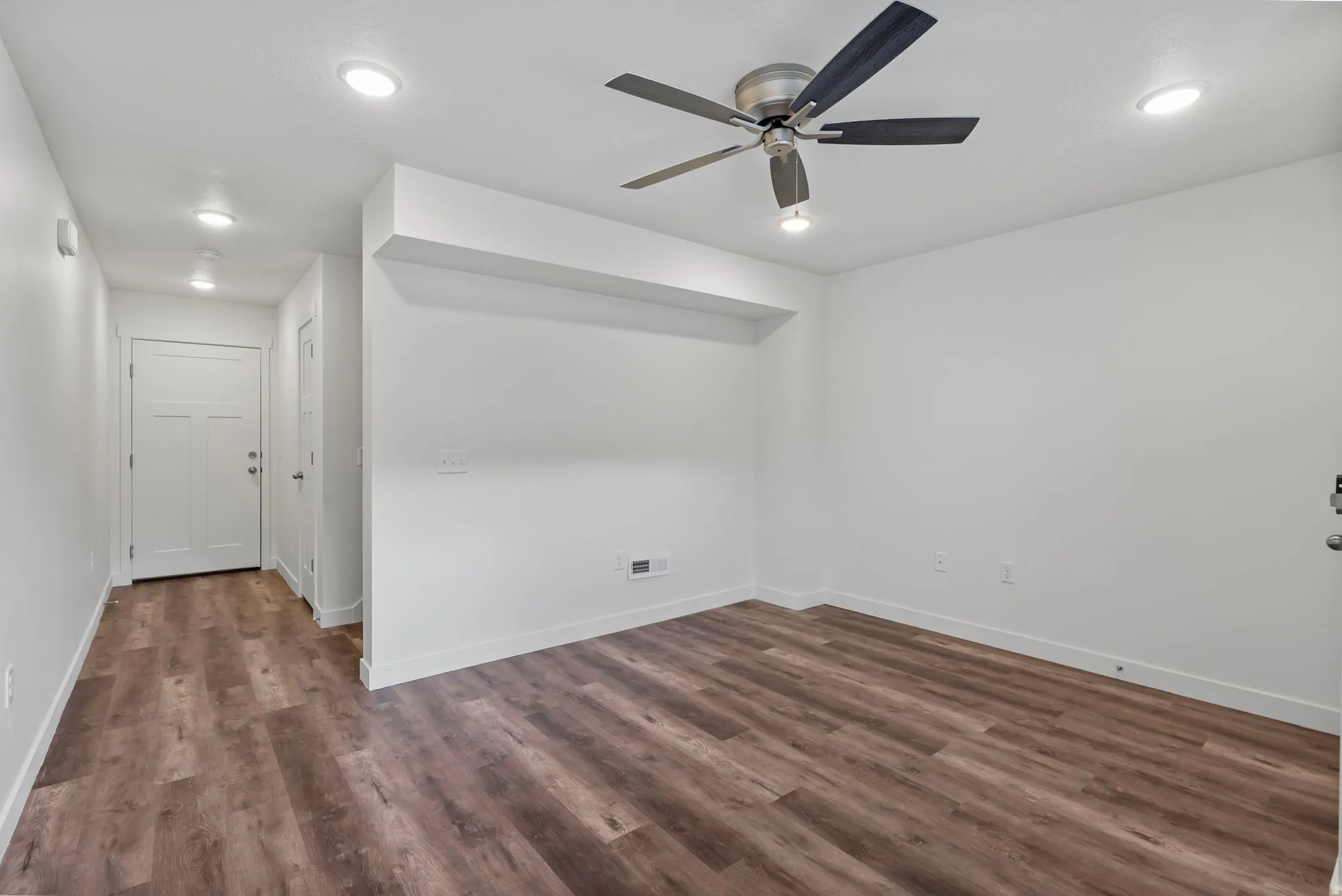 Living room with dark wood-style floors, ceiling fan, and recessed lighting