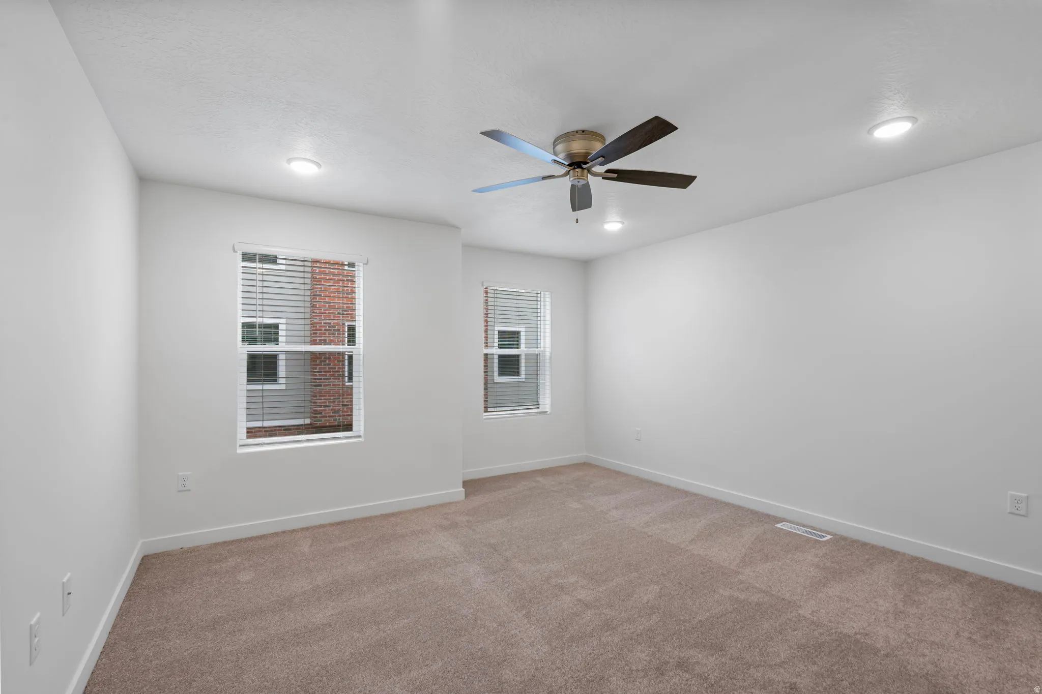 Primary bedroom with light carpet, healthy amount of natural light, and ceiling fan