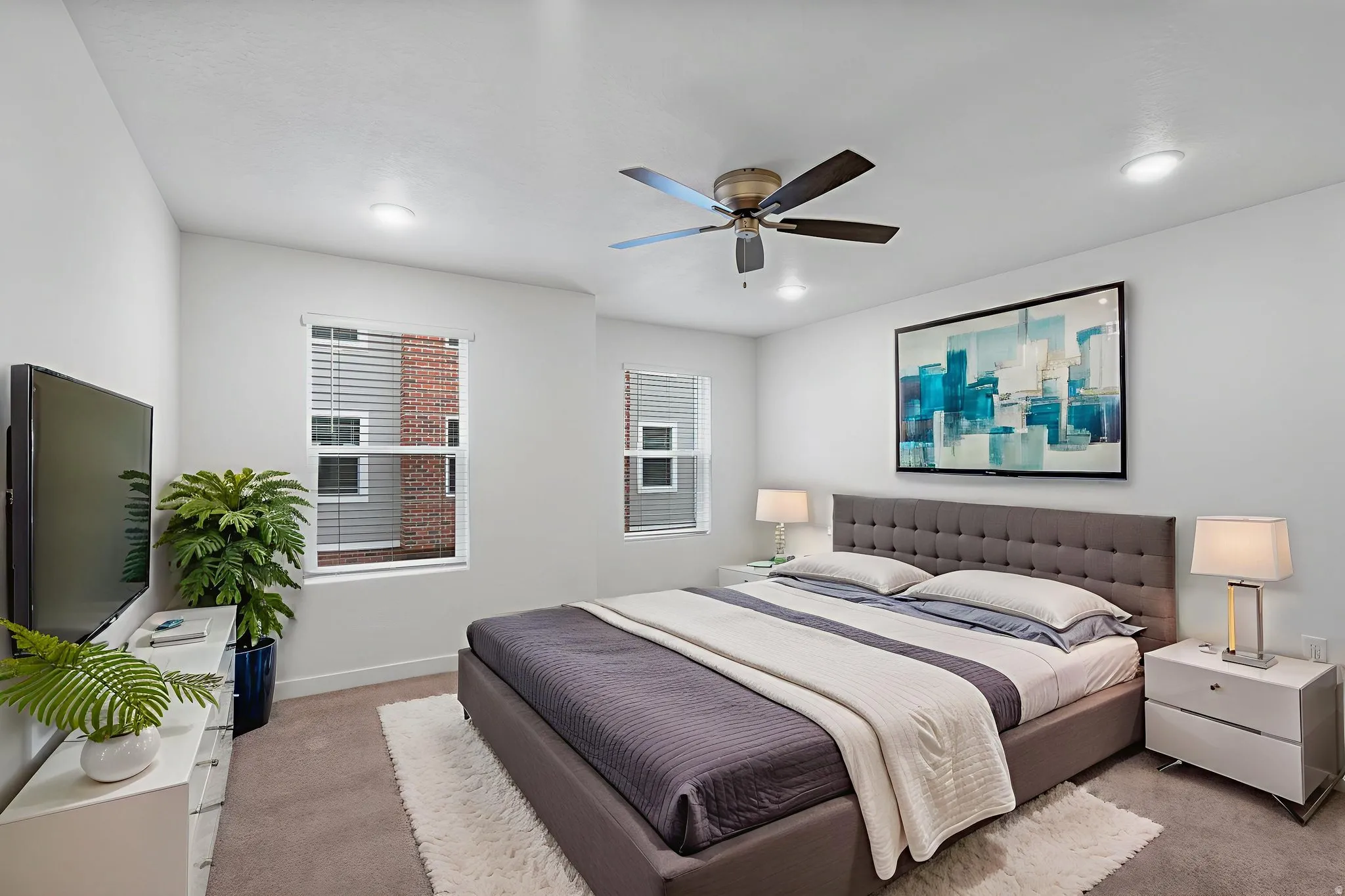 Primary Bedroom with light colored carpet and a ceiling fan