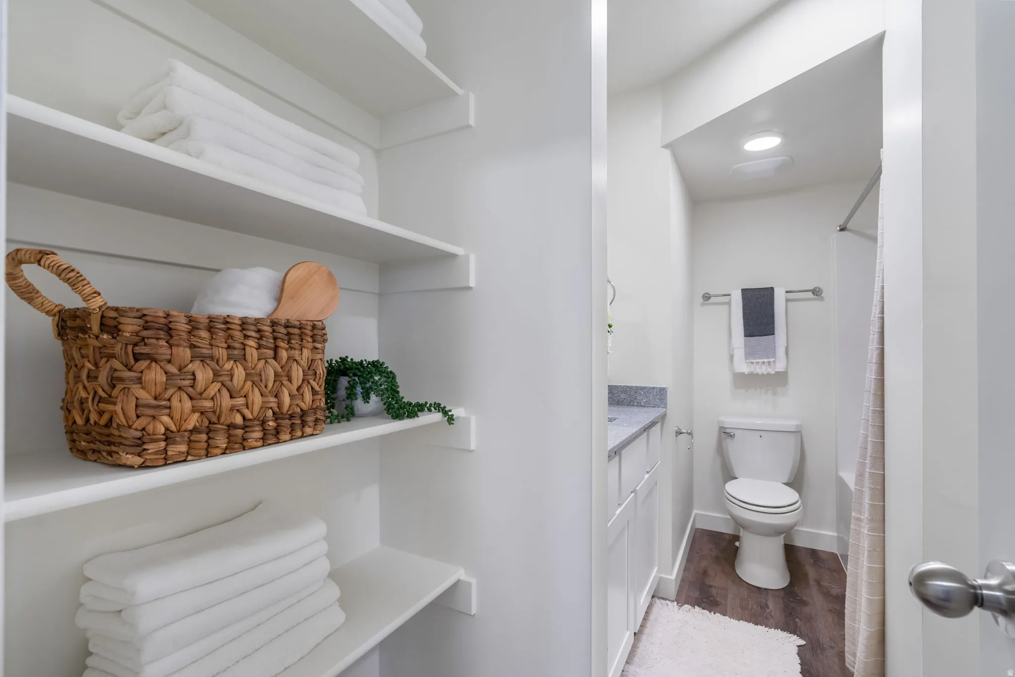 Primary ensuite bathroom with vanity, dark wood finished floors, and shower / bath combo