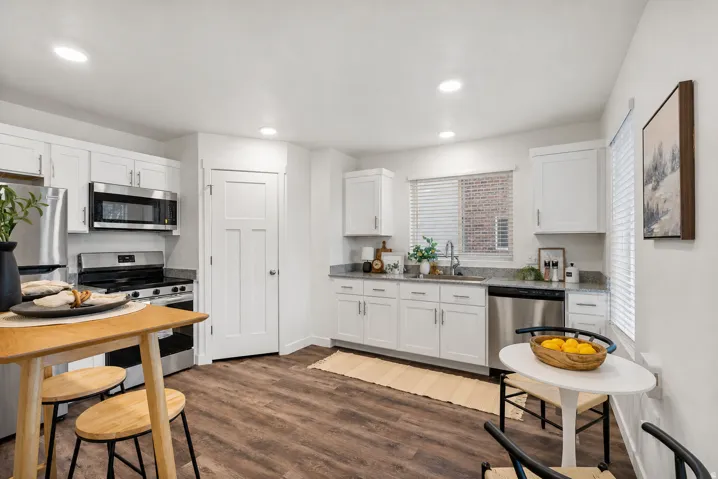 Kitchen featuring stainless steel appliances, white cabinets, dark wood-type flooring, and recessed lighting