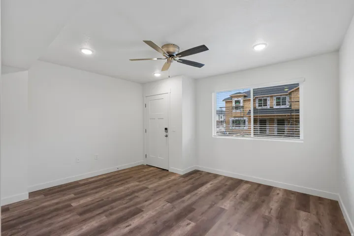 Living room featuring dark wood-style floors, ceiling fan, and recessed lighting
