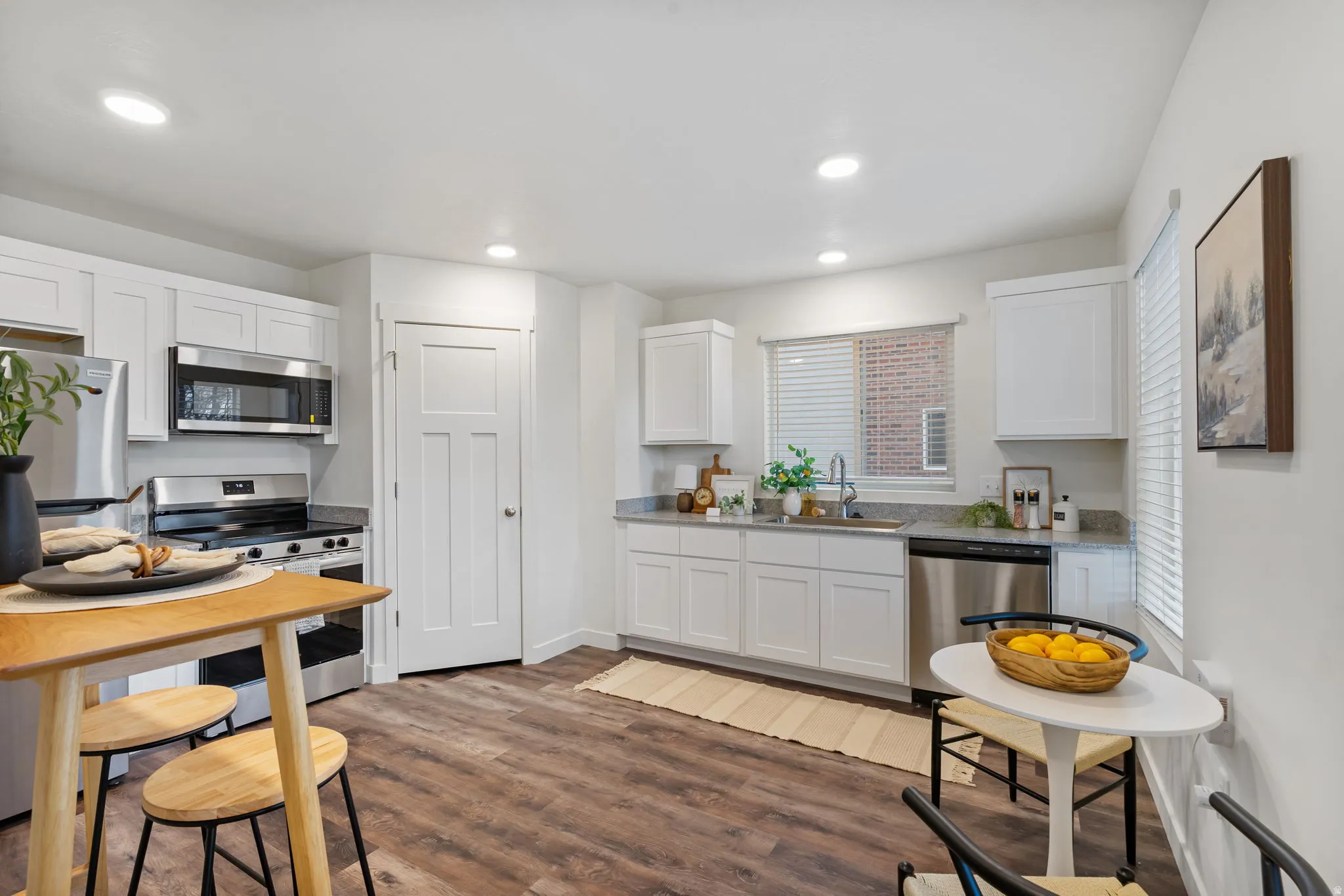 Kitchen featuring white cabinetry, appliances with stainless steel finishes, dark wood-style floors, and recessed lighting