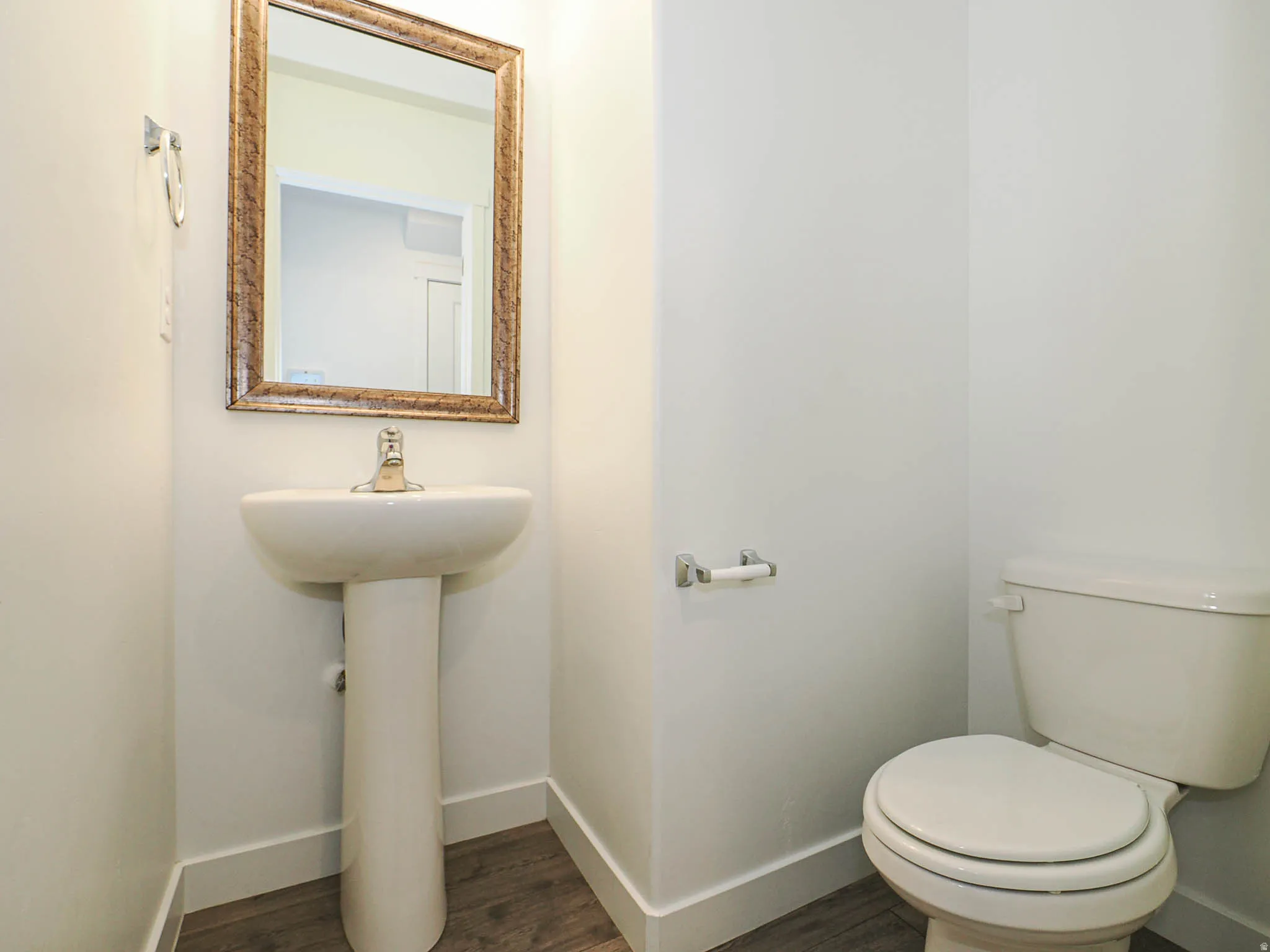 Half bath featuring baseboards and dark wood finished floors