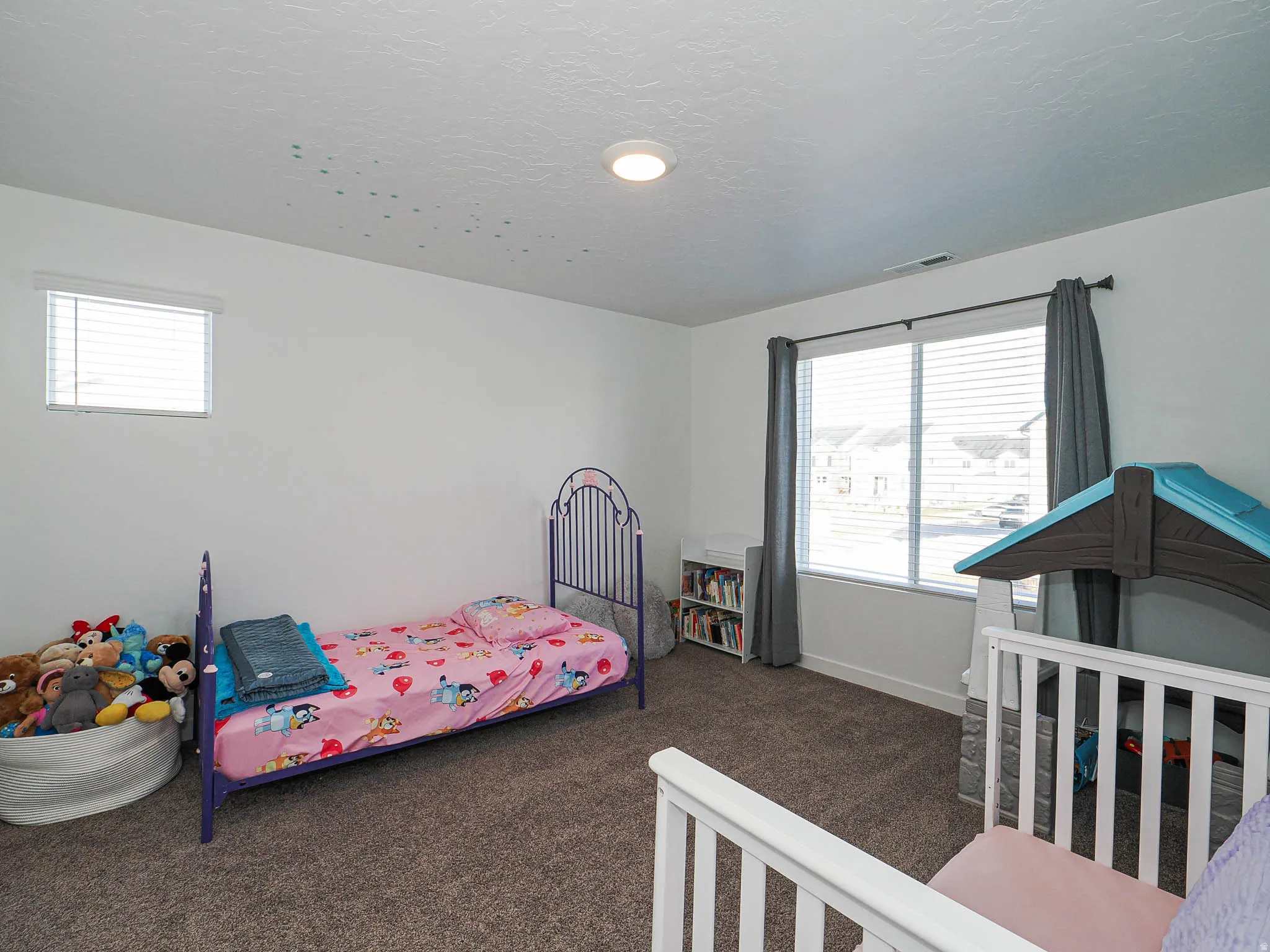 Carpeted bedroom featuring multiple windows