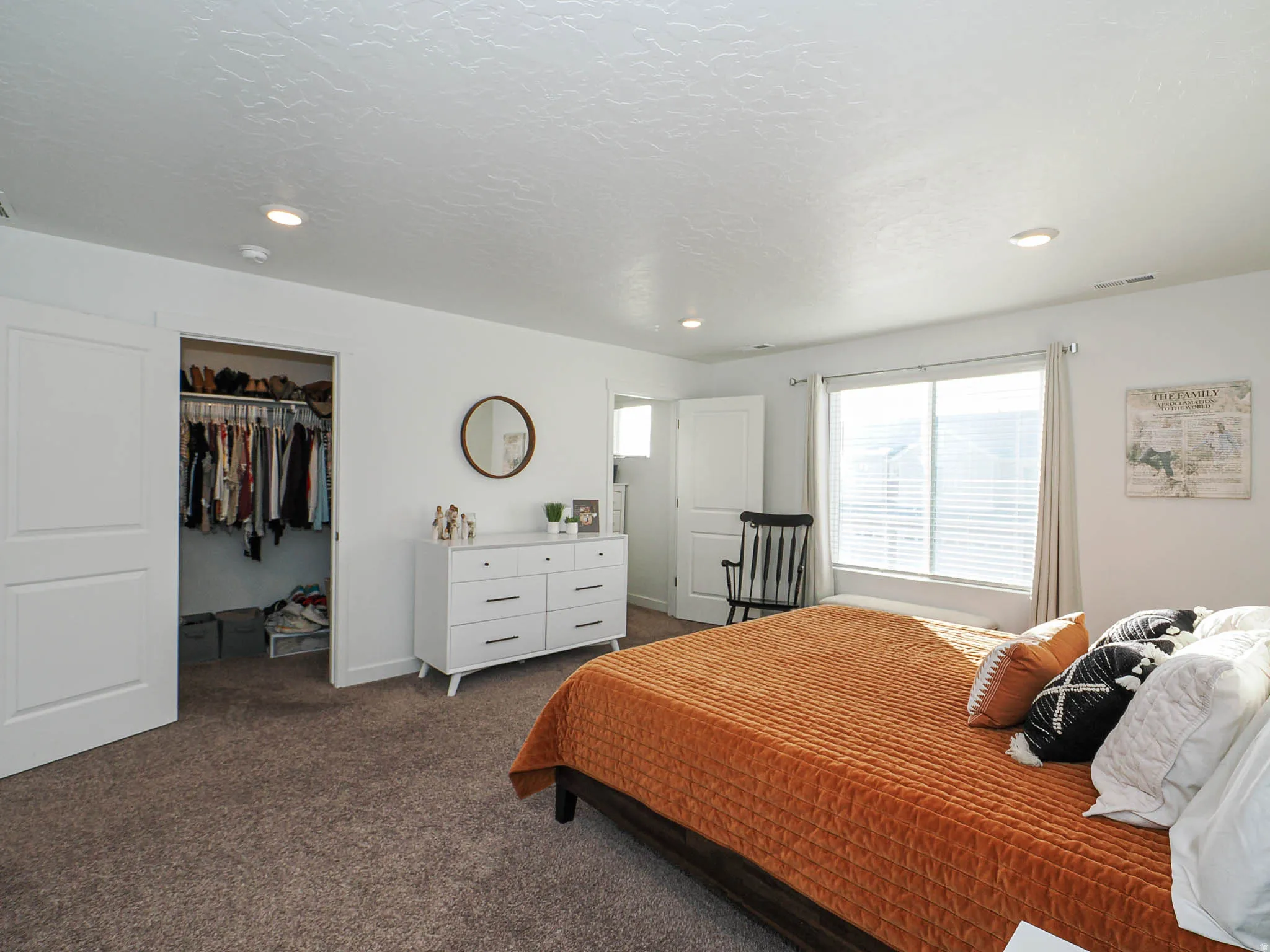Bedroom with a spacious closet, carpet flooring, recessed lighting, and a textured ceiling
