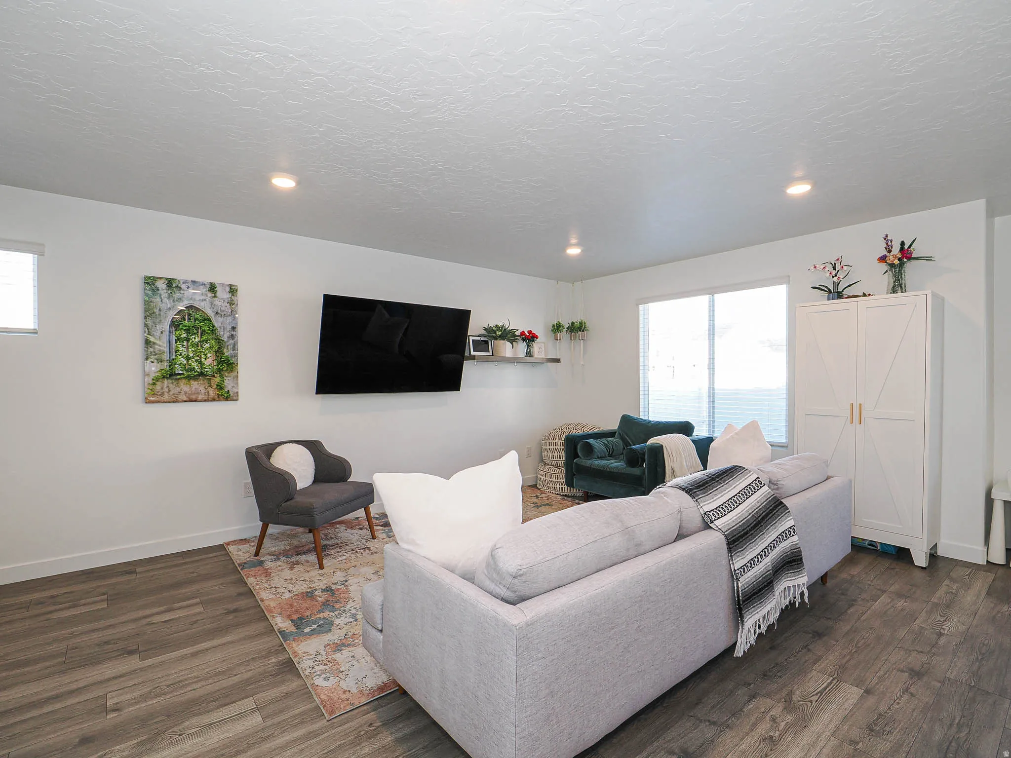 Living area featuring healthy amount of natural light, recessed lighting, dark wood-type flooring, and a textured ceiling