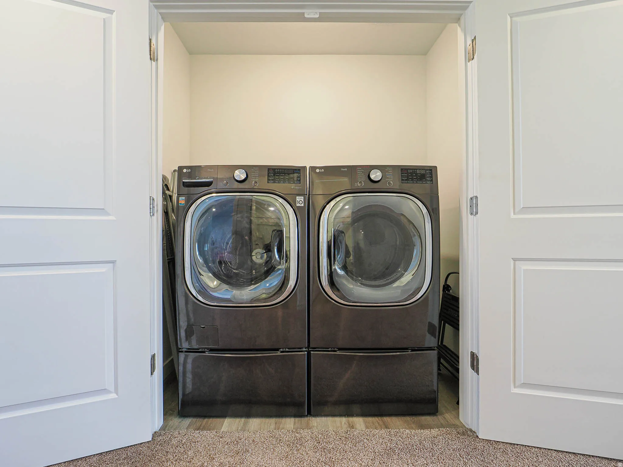 Laundry area with washer and dryer and carpet floors