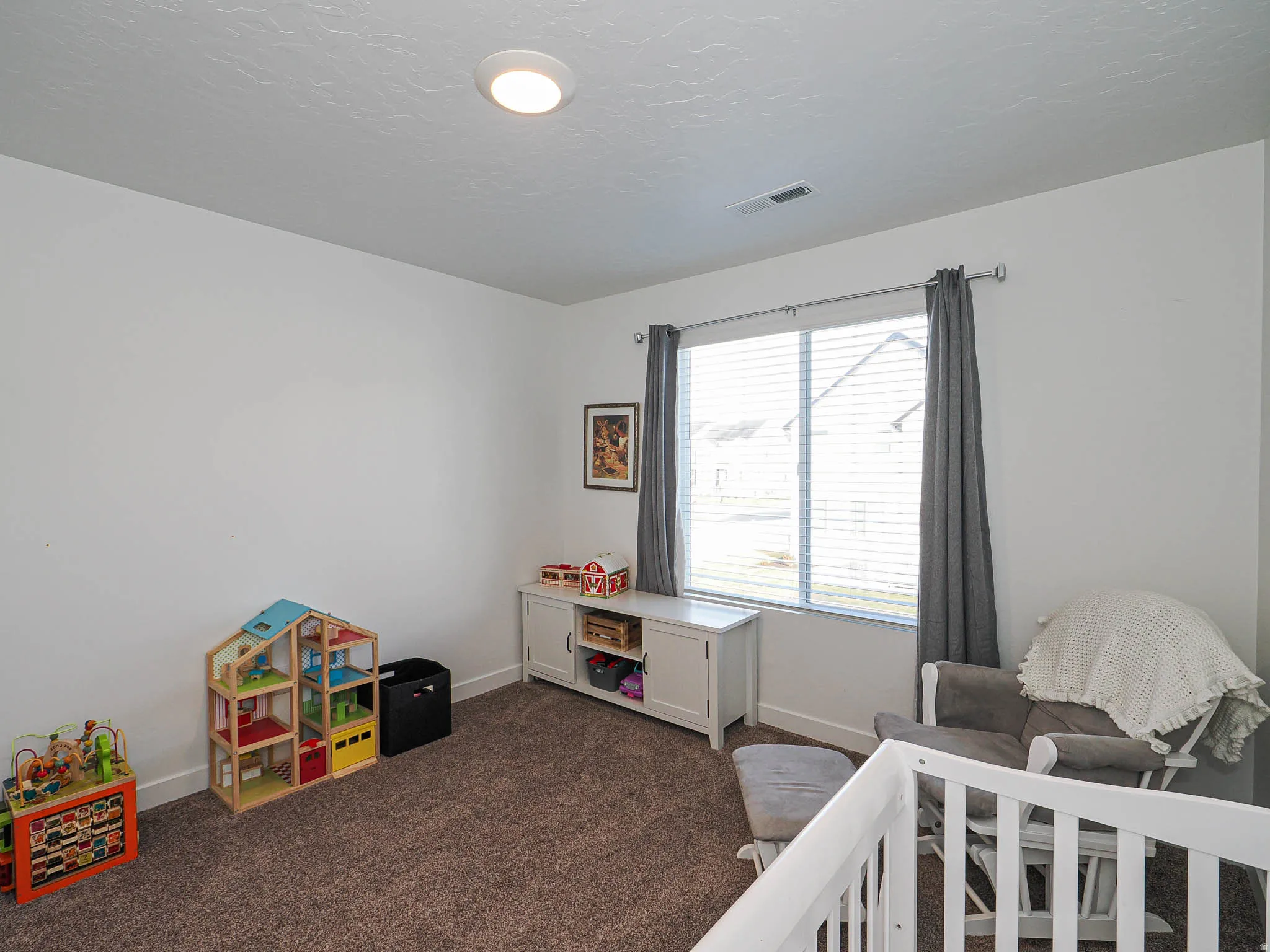 Bedroom featuring dark colored carpet and a textured ceiling