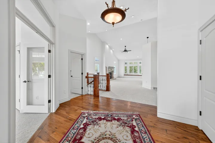 Foyer with wood-finish flooring transitioning to carpeted living areas