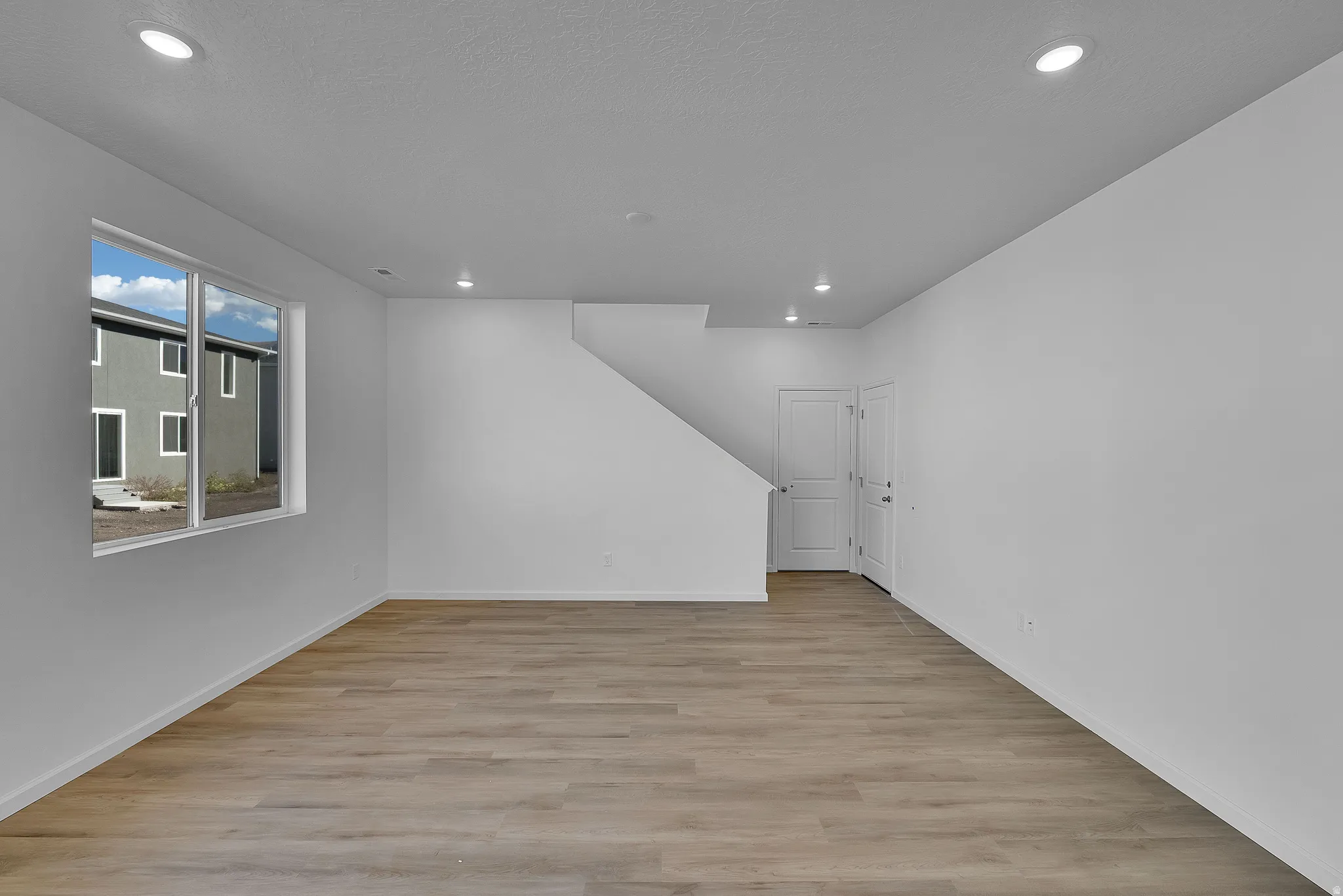 Empty room featuring light wood-type flooring and recessed lighting