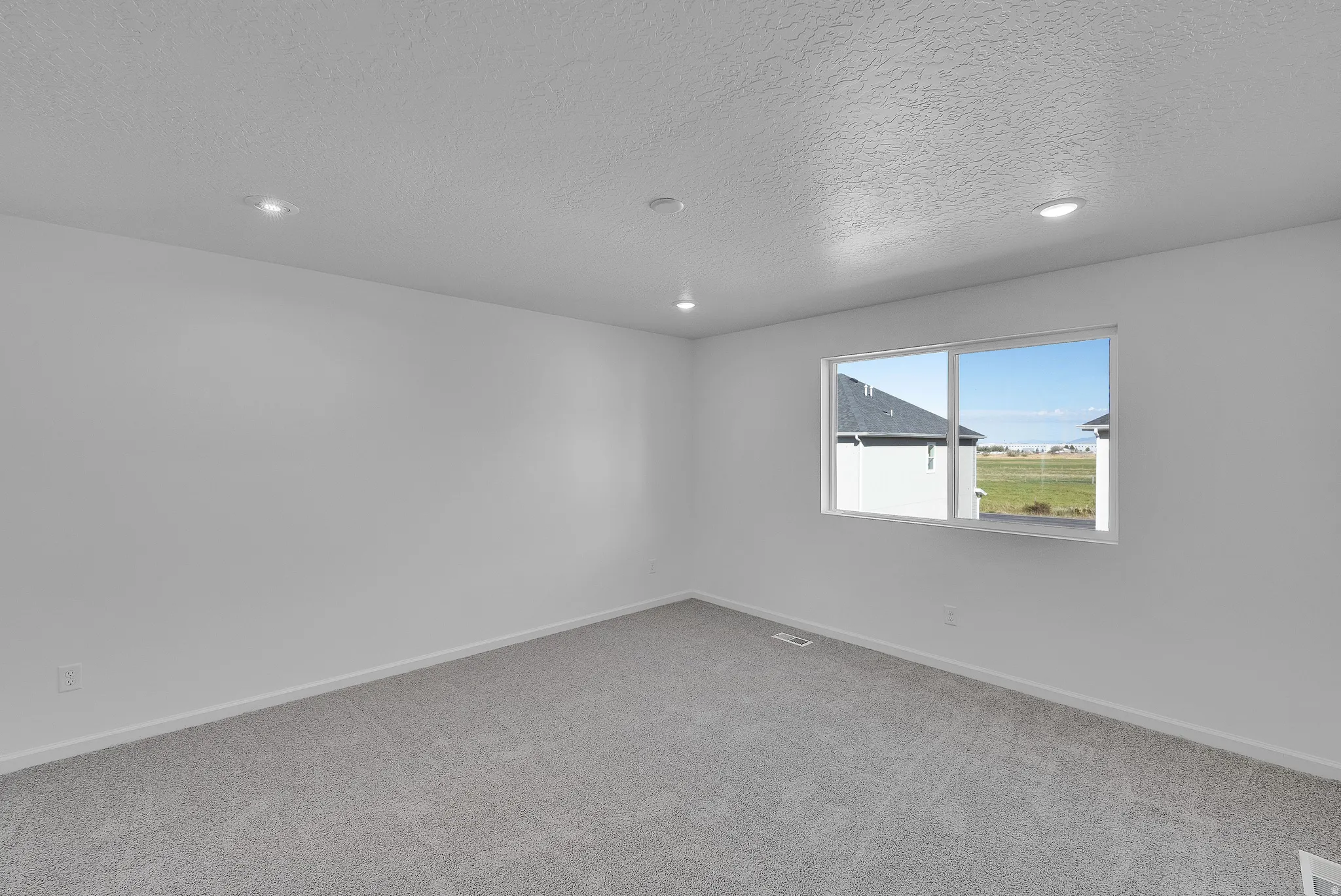 Spare room featuring a textured ceiling, light colored carpet, and recessed lighting
