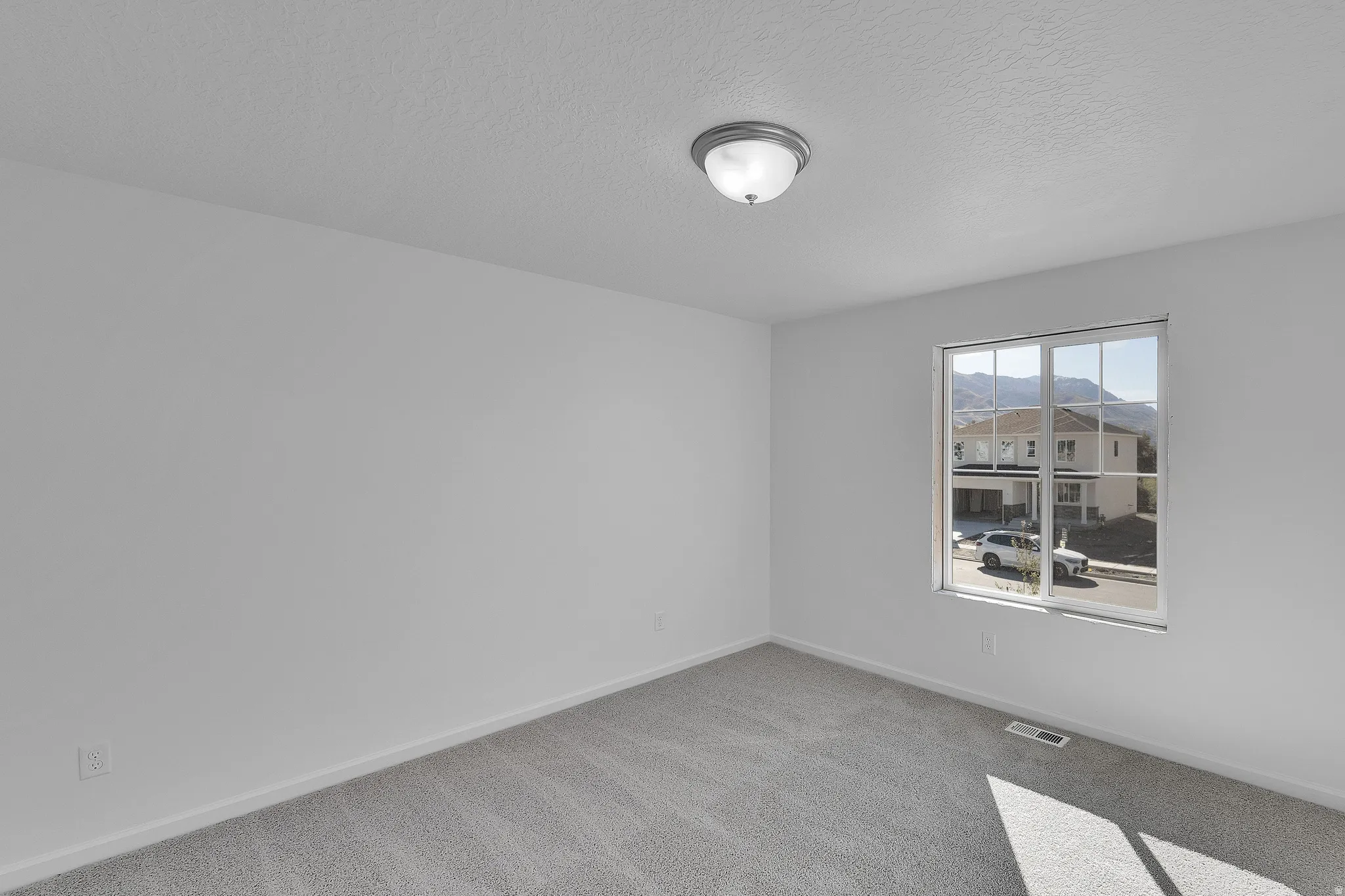 Unfurnished room with a textured ceiling and light carpet