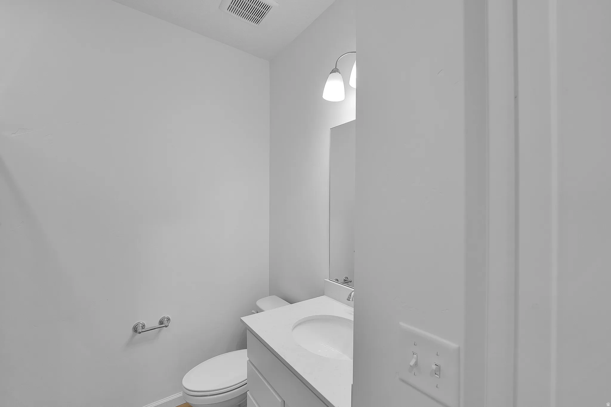 Half bathroom with vanity and toilet