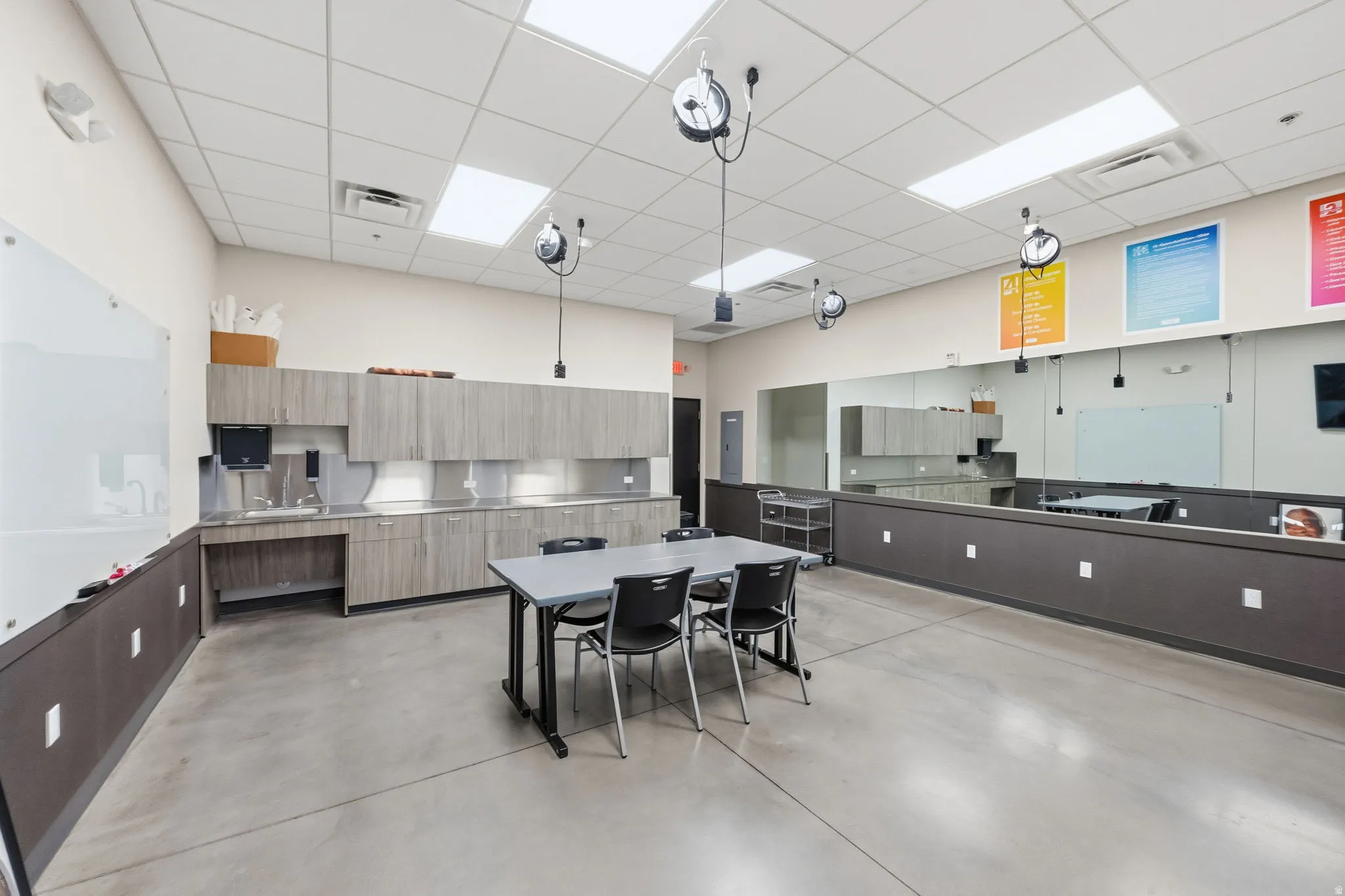 Kitchen featuring modern cabinets, light brown cabinets, hanging light fixtures, and a drop ceiling