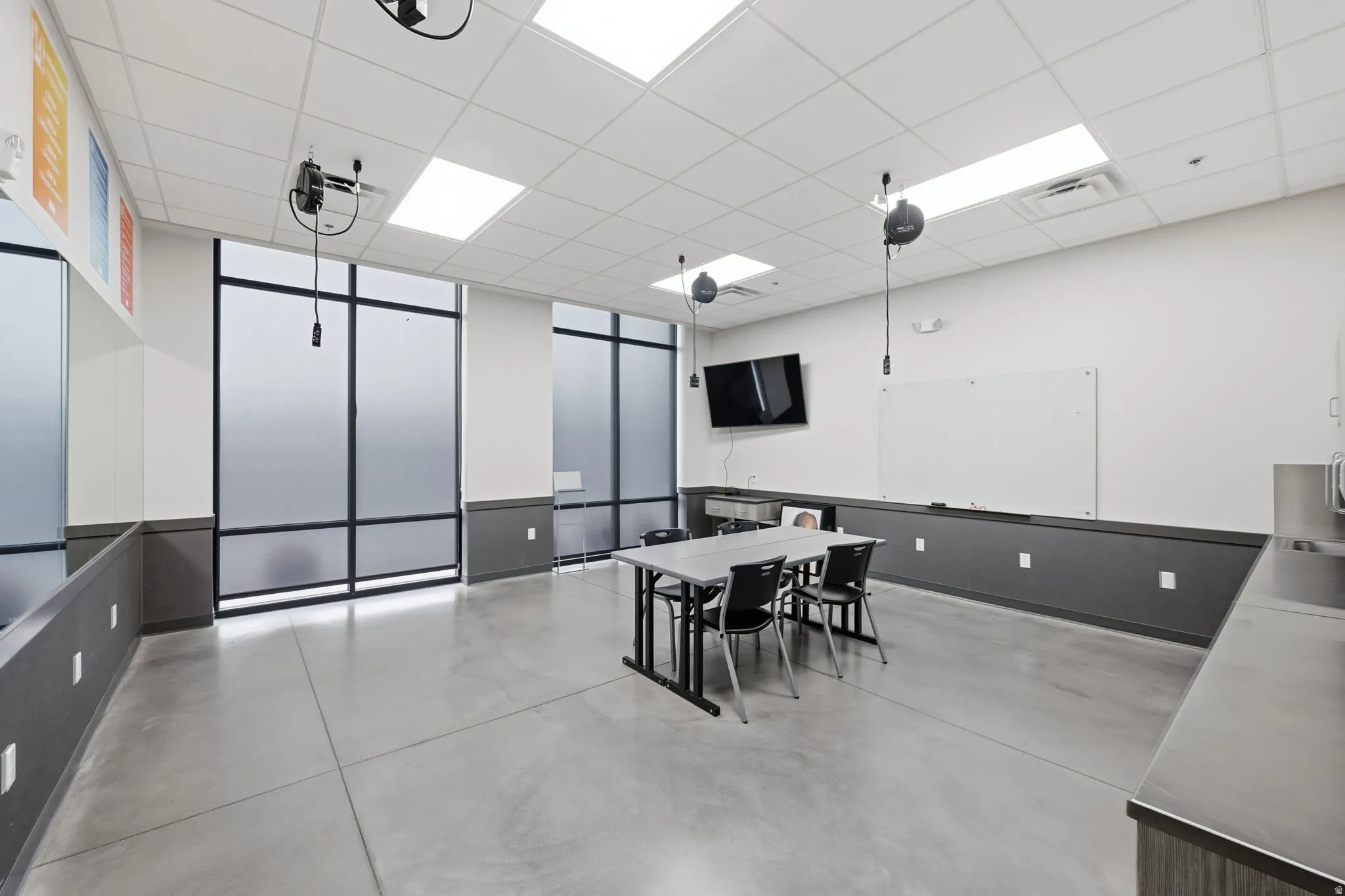 Dining space with a paneled ceiling and concrete floors