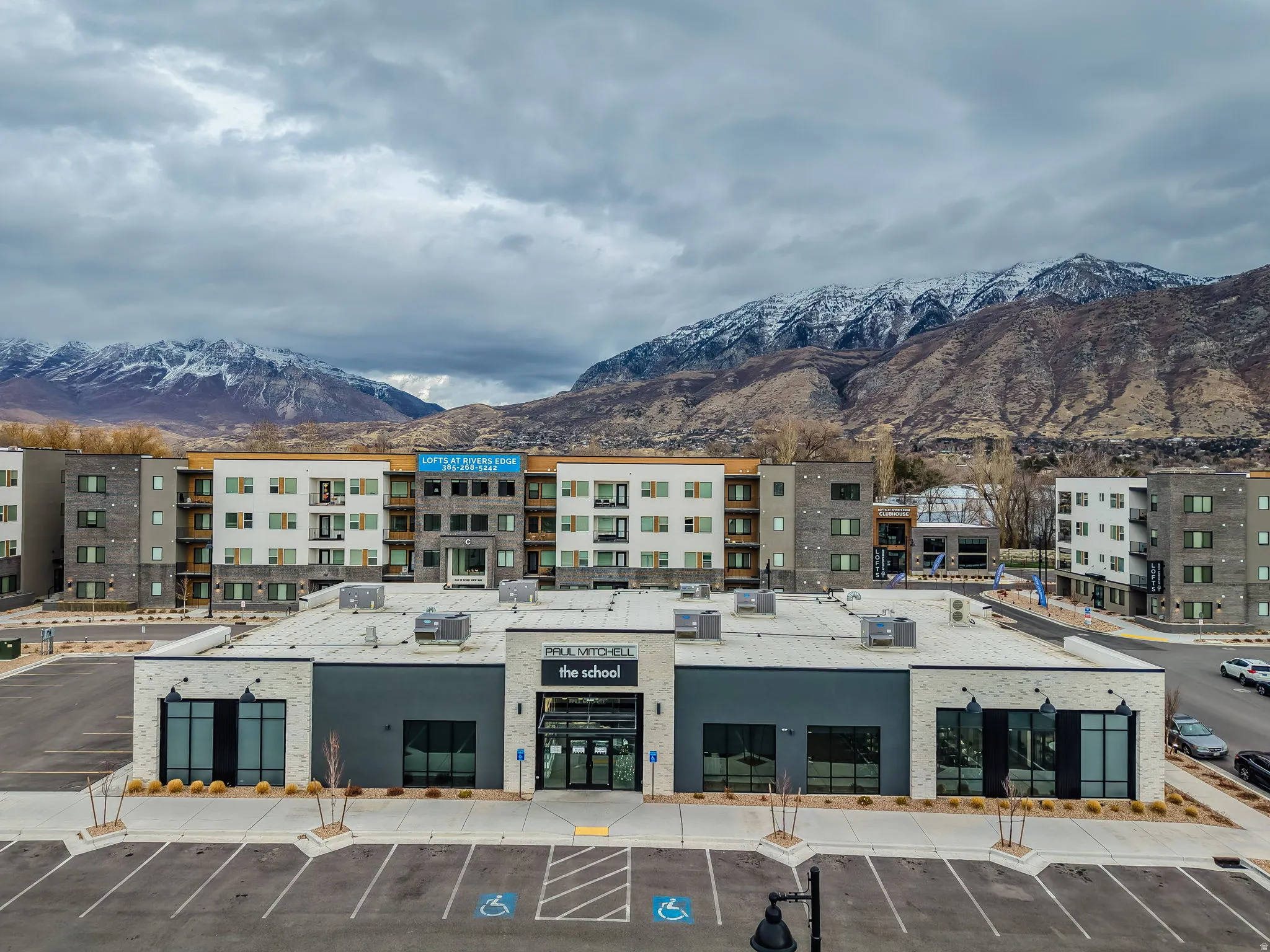 View of building exterior featuring a mountain view and uncovered parking