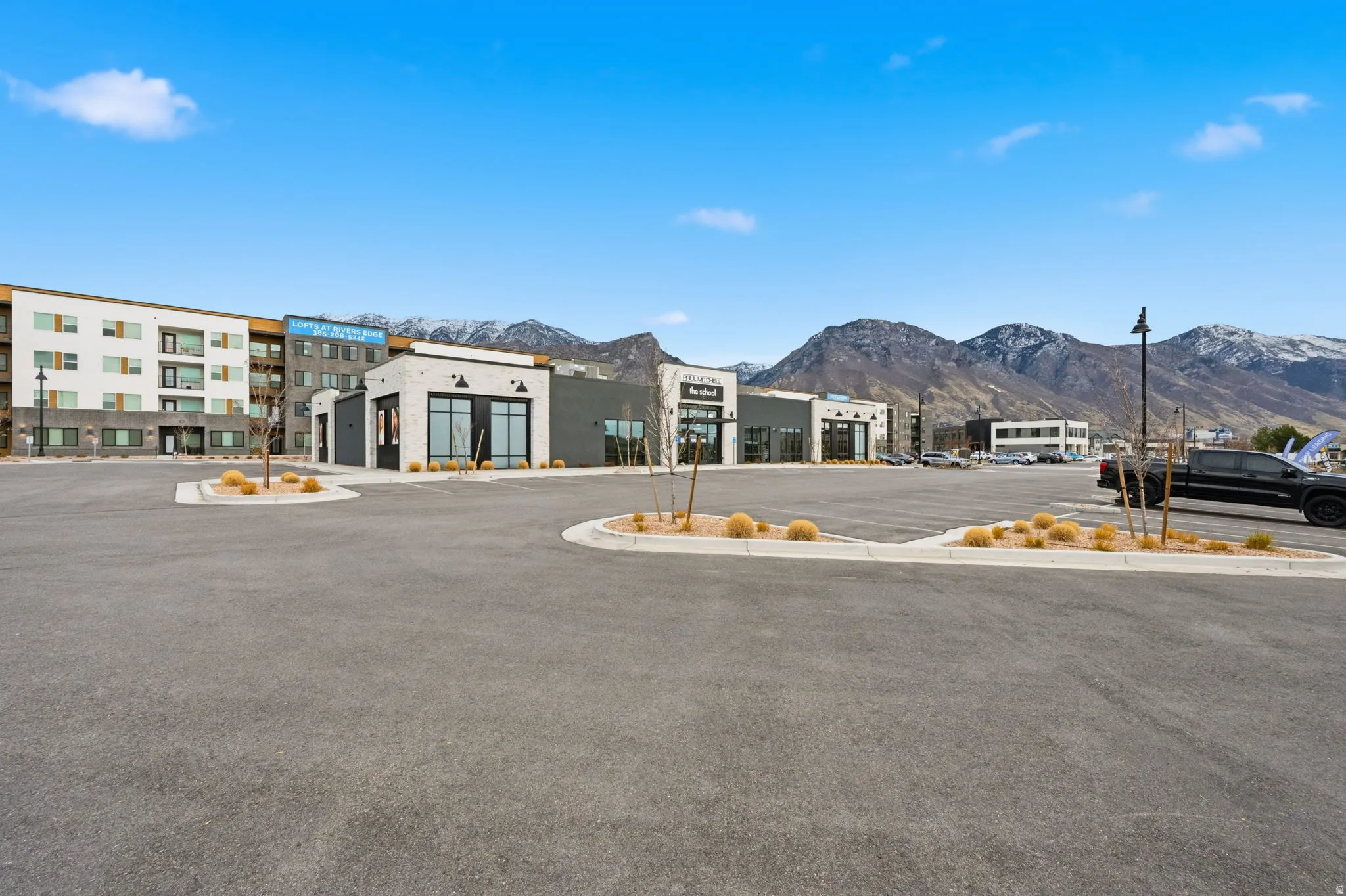 View of asphalt street featuring street lighting, a mountain view, and curbs