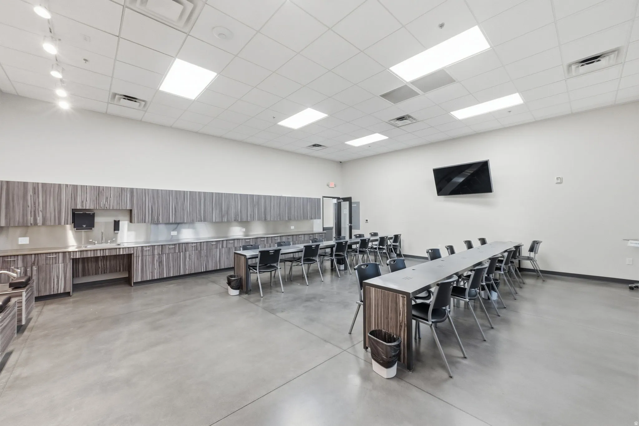 Dining room with finished concrete floors, a paneled ceiling, and a towering ceiling