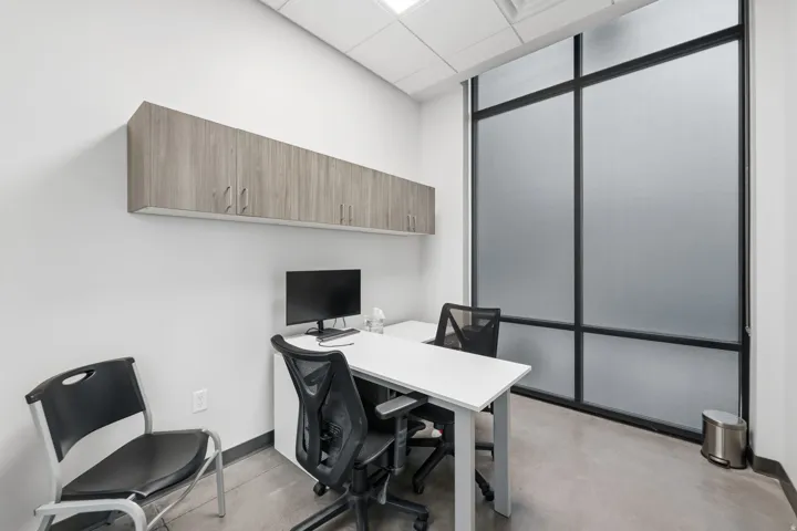 Office area with a drop ceiling and concrete floors