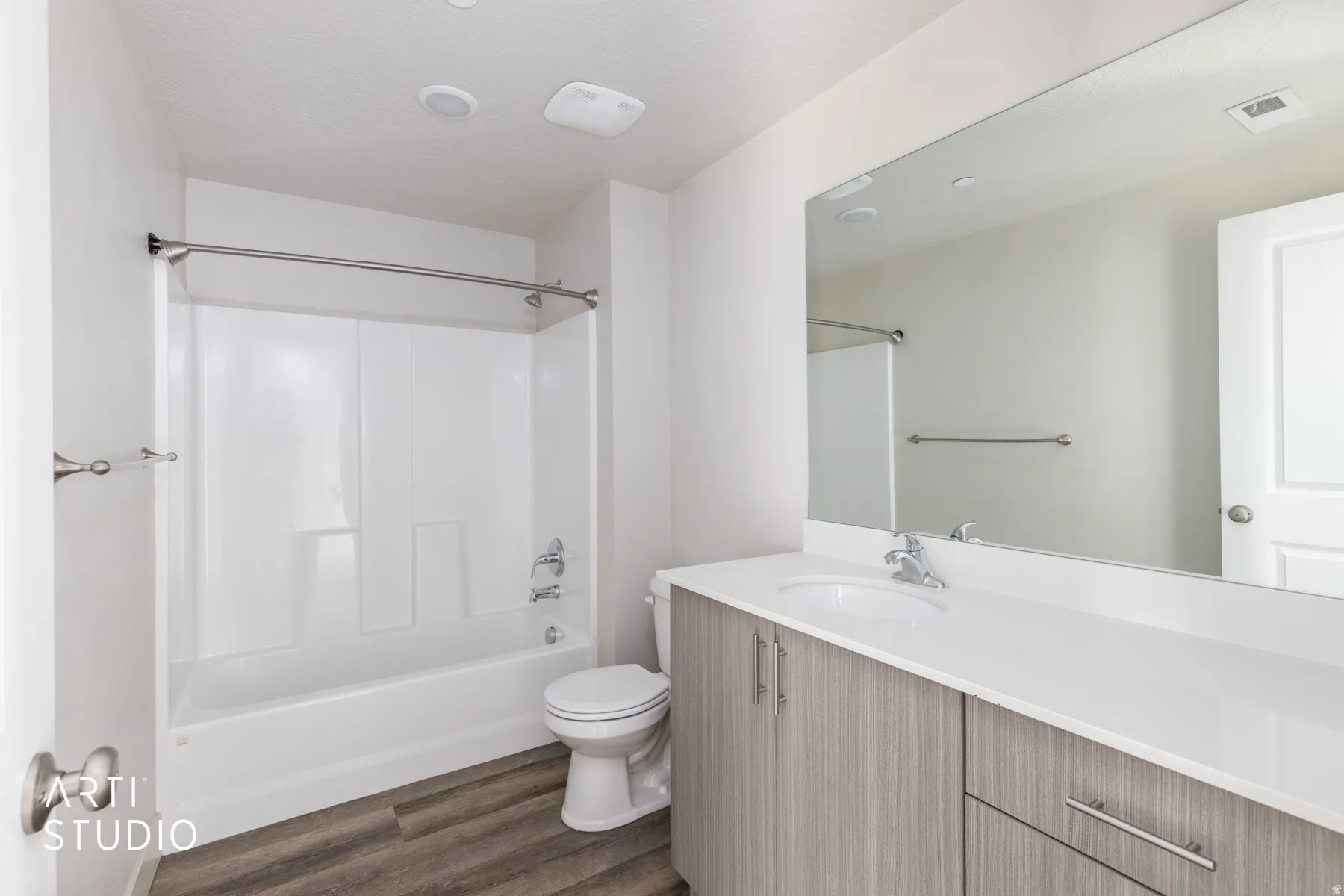 Full bathroom with bathtub / shower combination, vanity, dark wood finished floors, and a textured ceiling