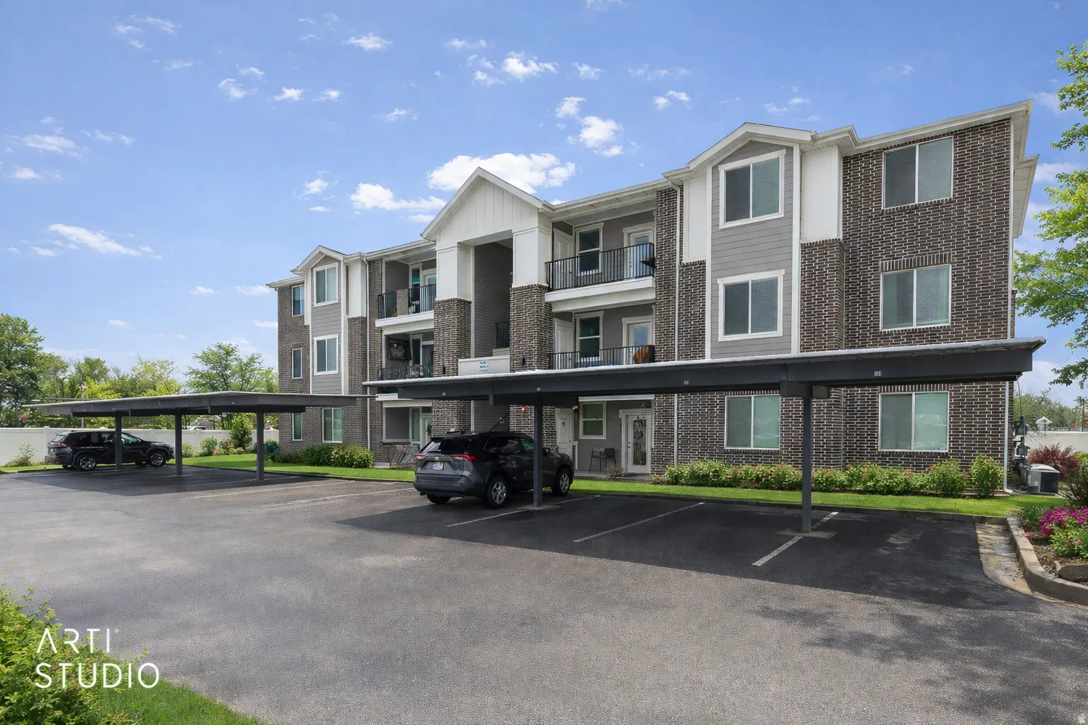 View of apartment building / complex featuring covered parking