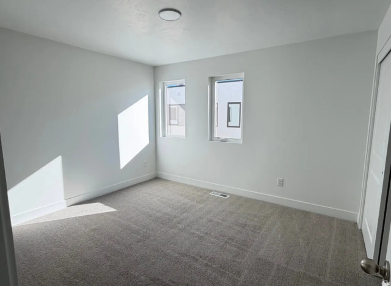 Unfurnished bedroom featuring light carpet and a closet