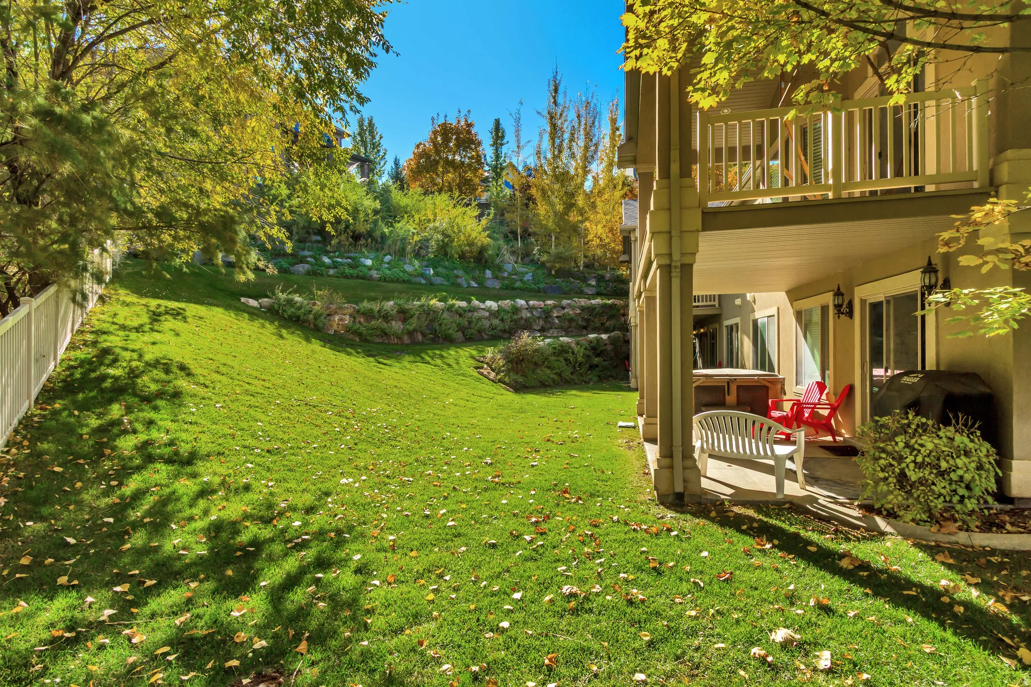 View of grassy yard with a patio area and a deck