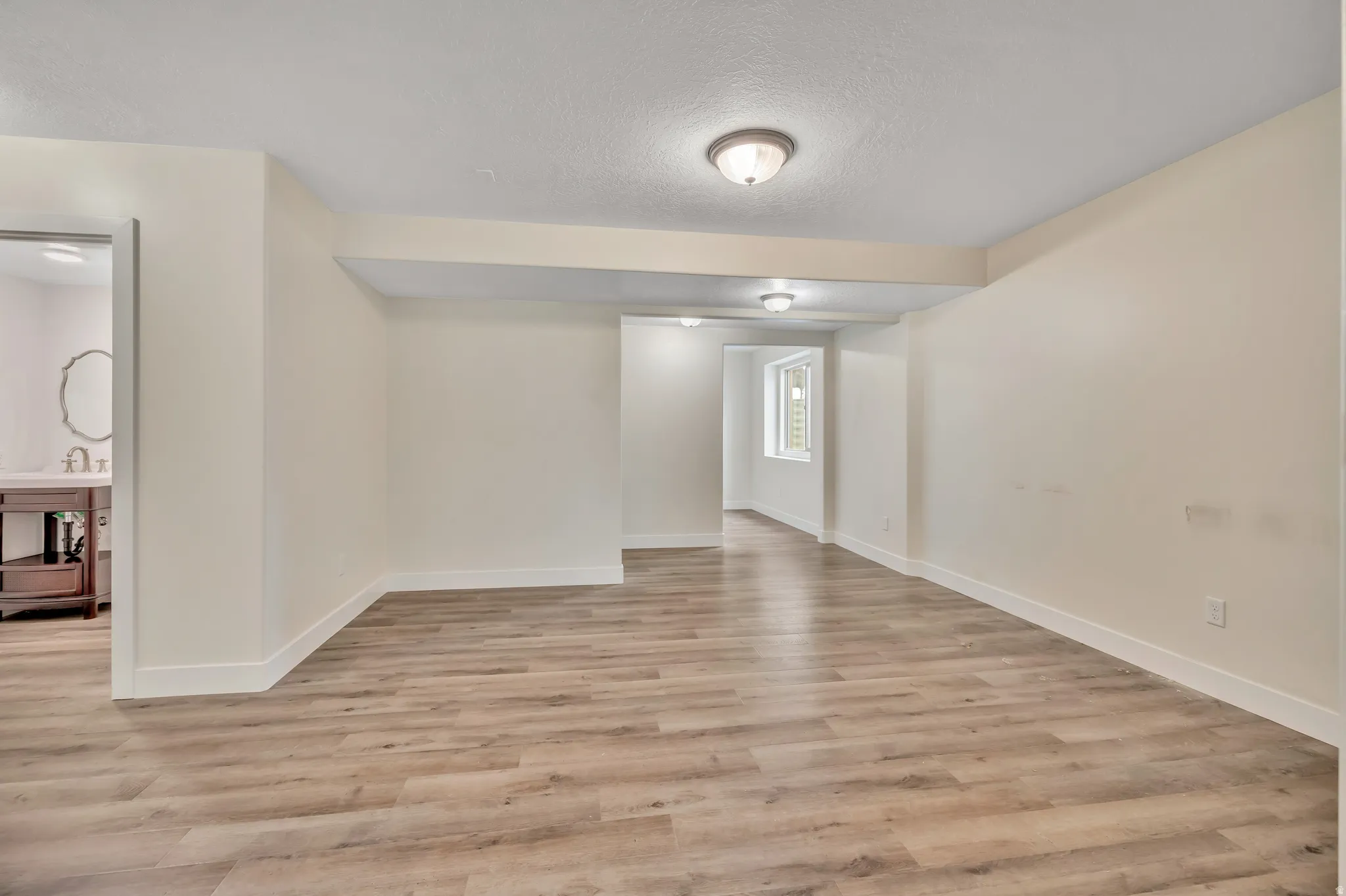 Spare room with a textured ceiling and light wood-style flooring