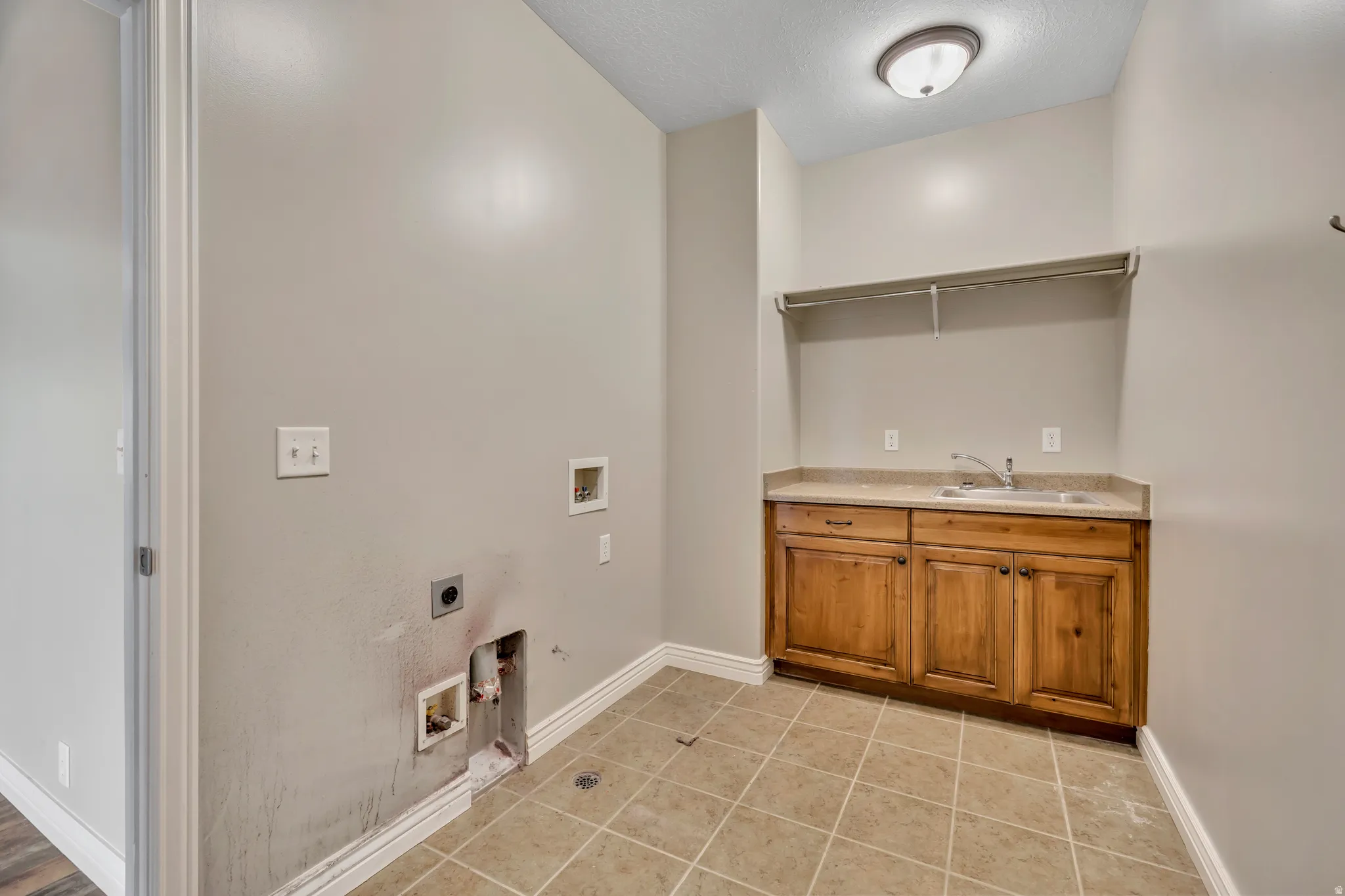 Washroom with washer hookup, gas dryer hookup, light tile patterned floors, a textured ceiling, and electric dryer hookup