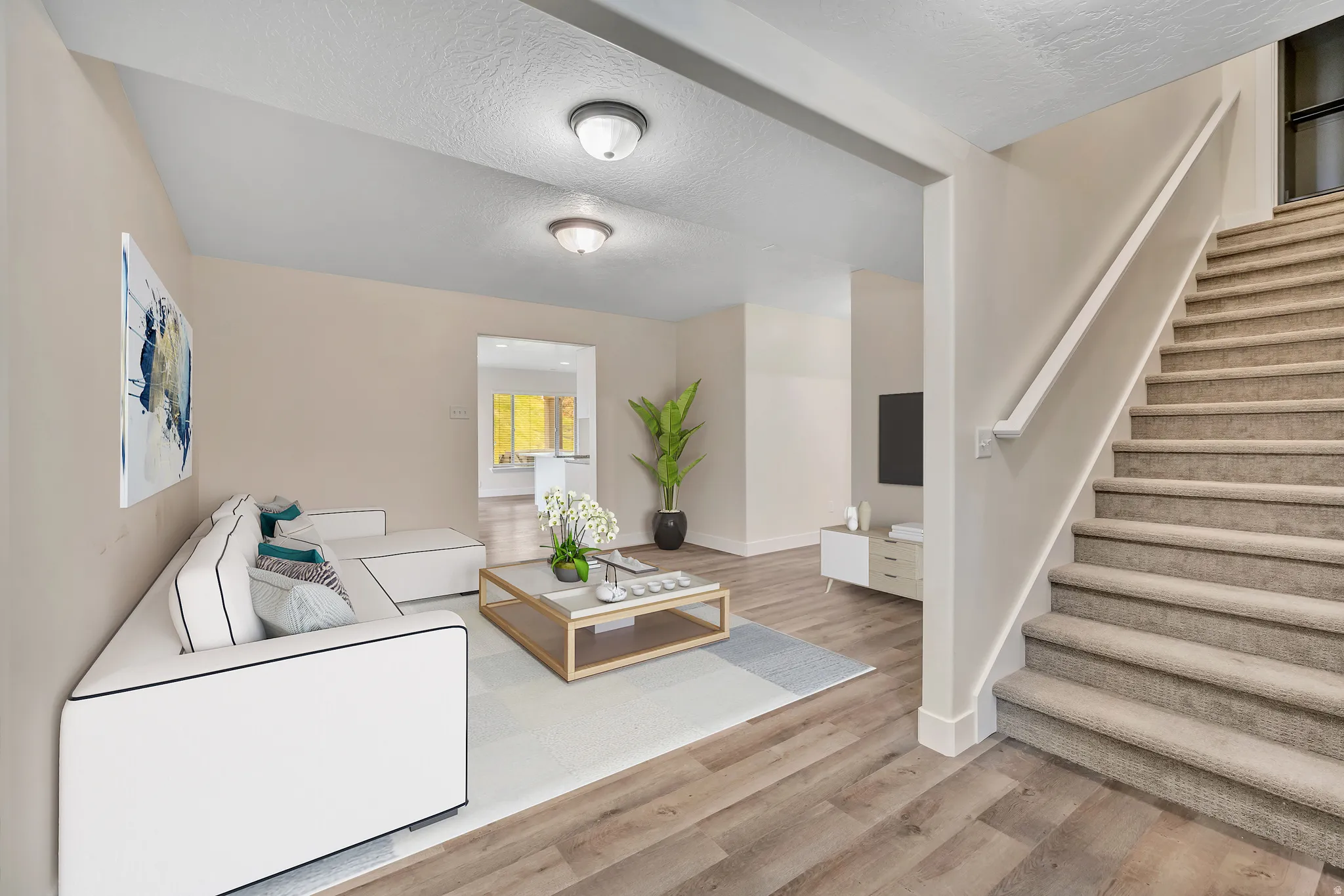Downstairs Living room featuring stairs, a textured ceiling, and light wood-style flooring