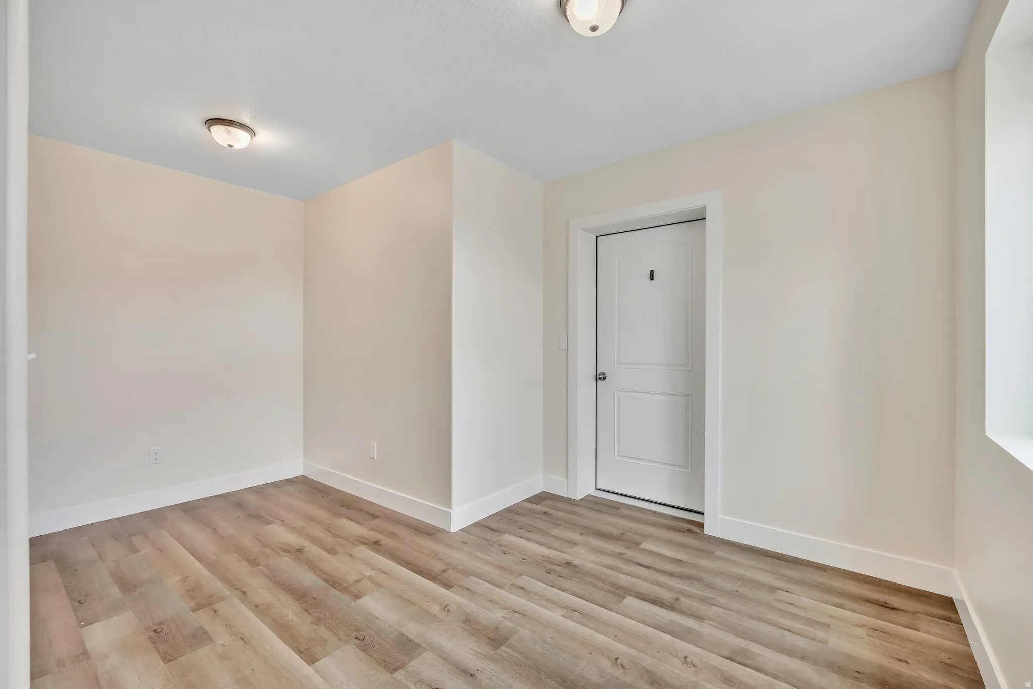 Empty room with light wood finished floors and baseboards