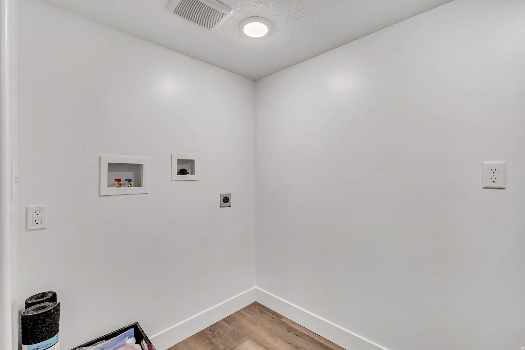 Laundry area featuring hookup for a washing machine, light wood-style floors, and hookup for an electric dryer