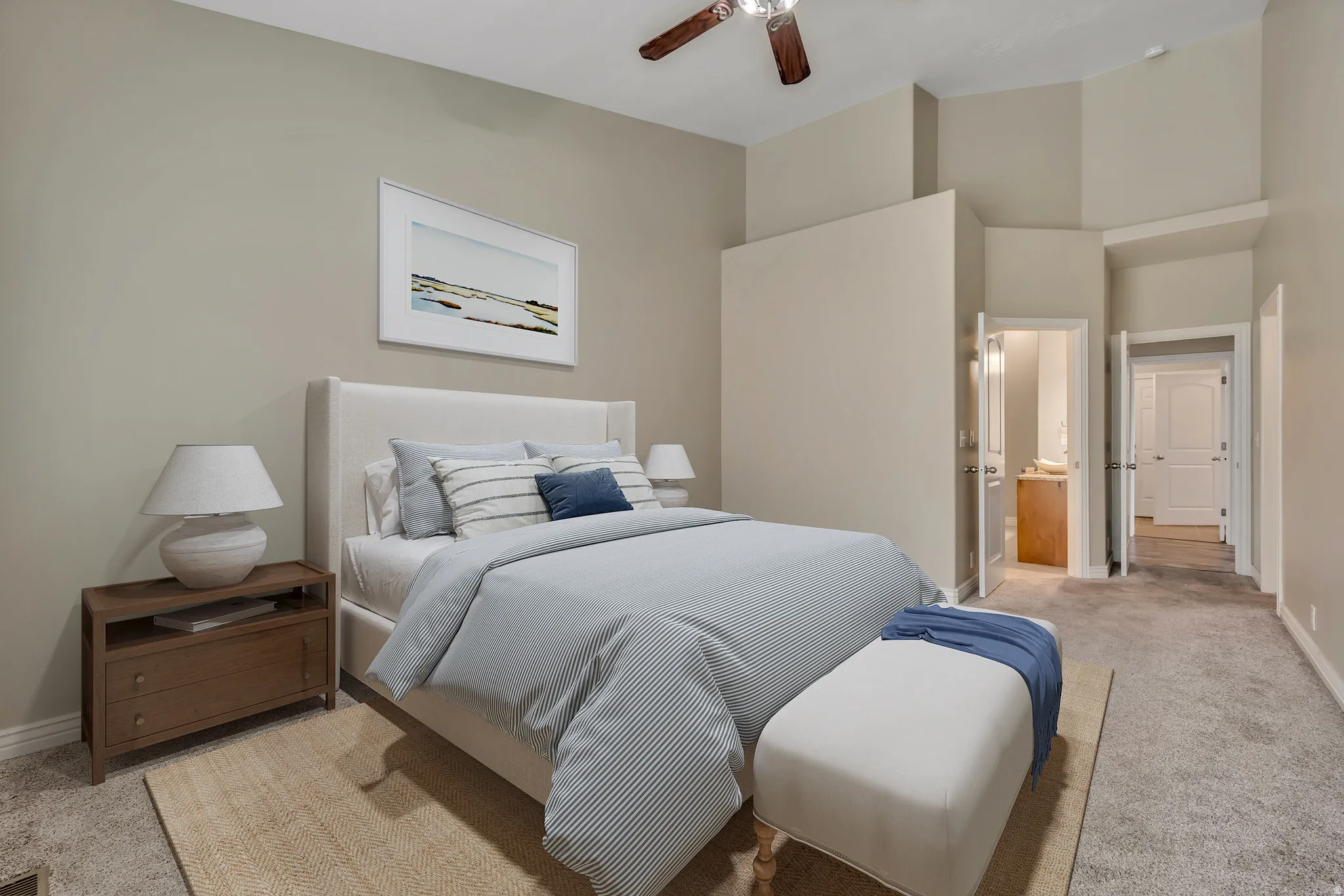 Bedroom featuring light carpet, ensuite bathroom, and ceiling fan