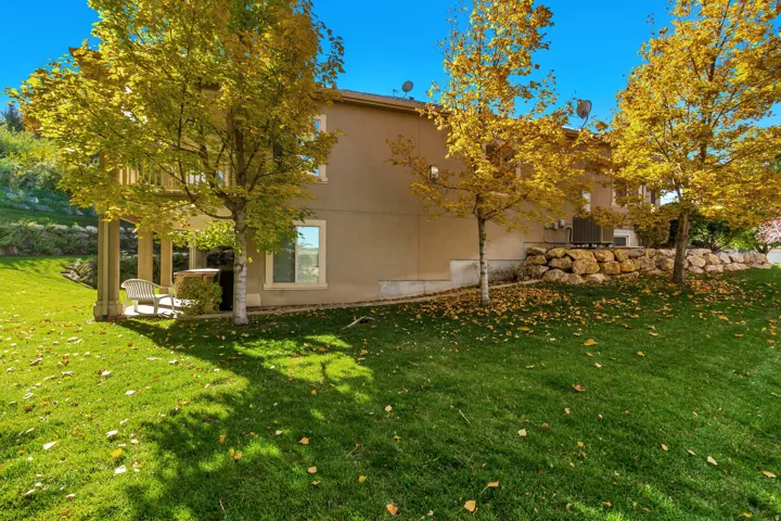 View of side of property with a yard, stucco siding, and a patio