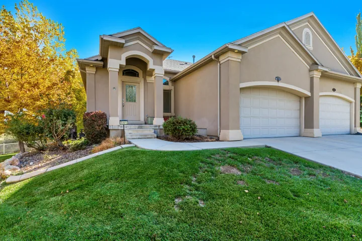 Mediterranean / spanish-style home featuring stucco siding, a front yard, driveway, and a garage