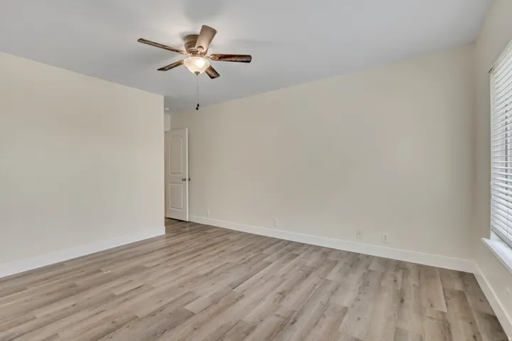Empty room with light wood finished floors and ceiling fan