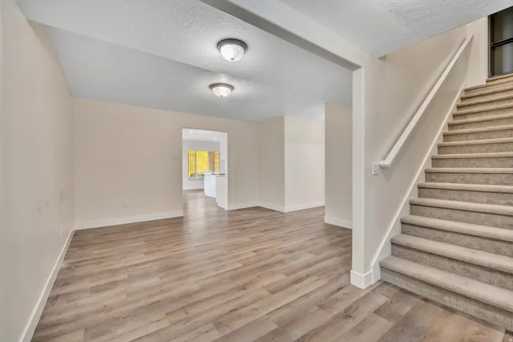 Stairs featuring a textured ceiling and wood finished floors