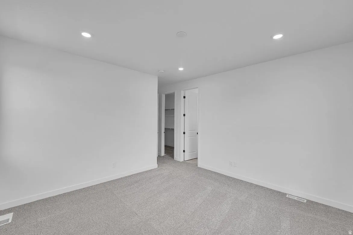 Carpeted empty room with recessed lighting