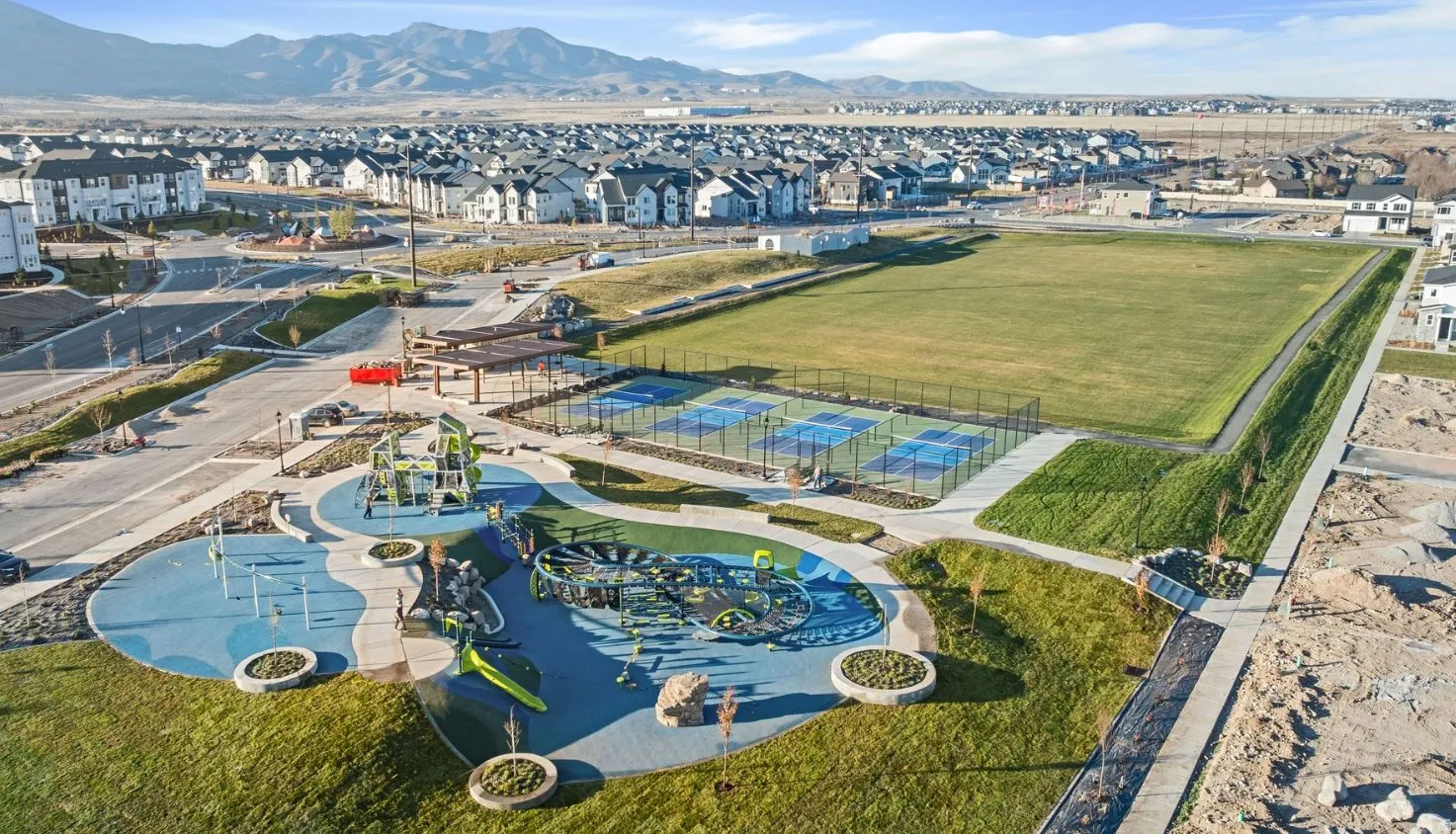 Aerial perspective of suburban area with mountains and a community park