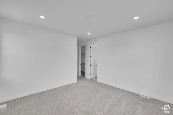 Carpeted empty room with recessed lighting