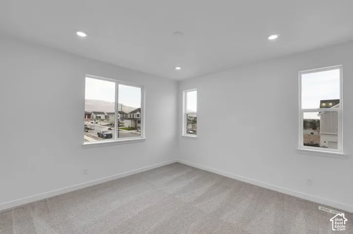 Empty room featuring light carpet and recessed lighting