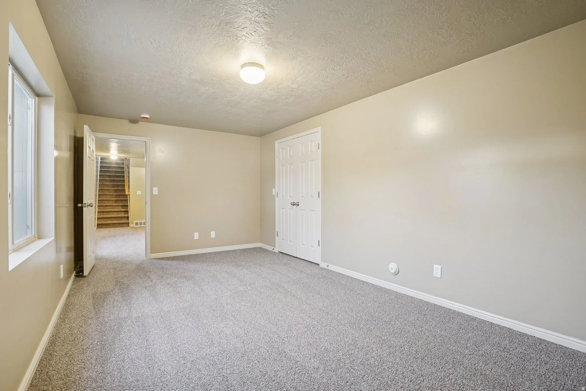 Unfurnished bedroom featuring carpet and a textured ceiling